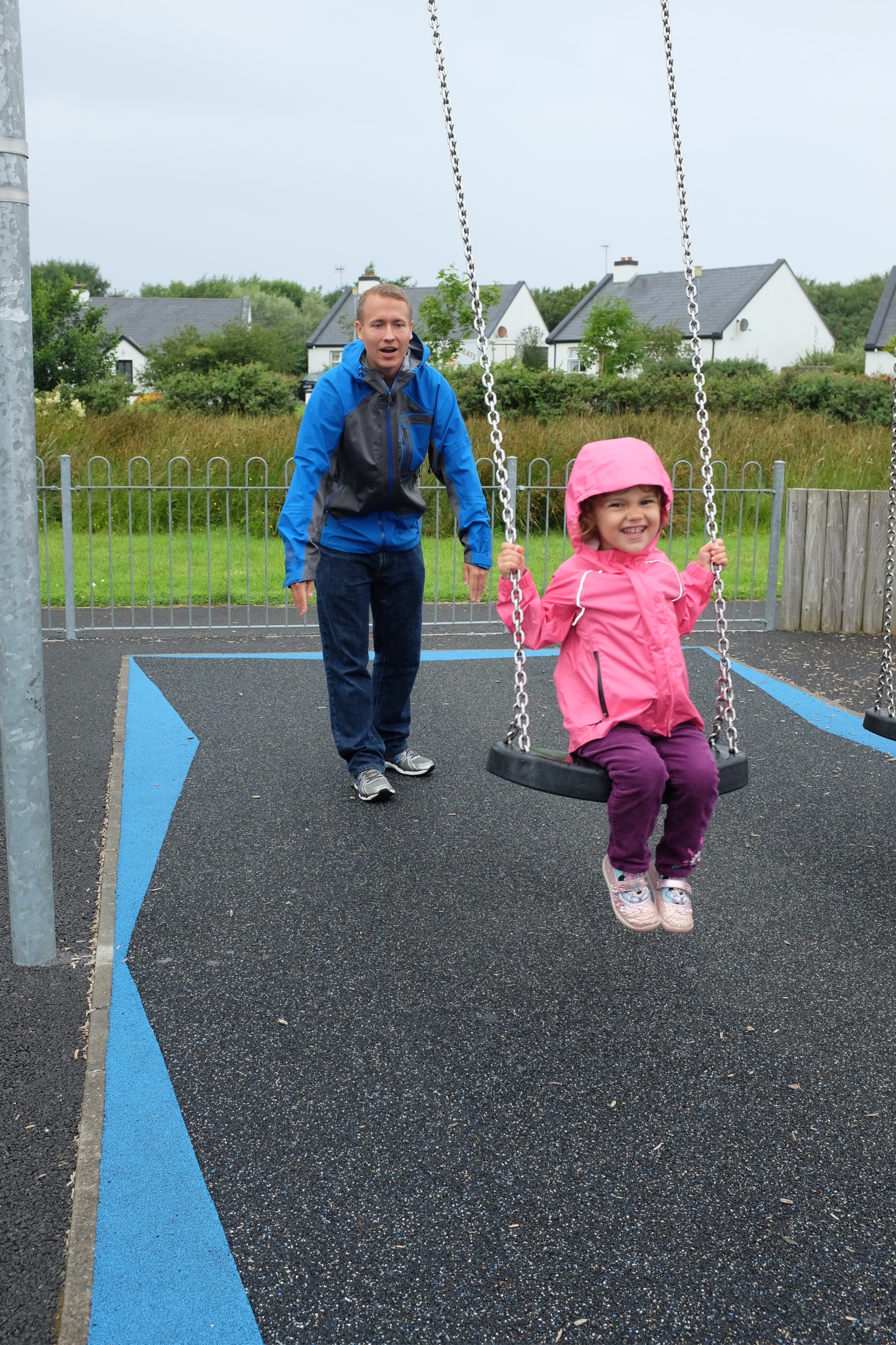 Hannah being pushed on the swing by daddy