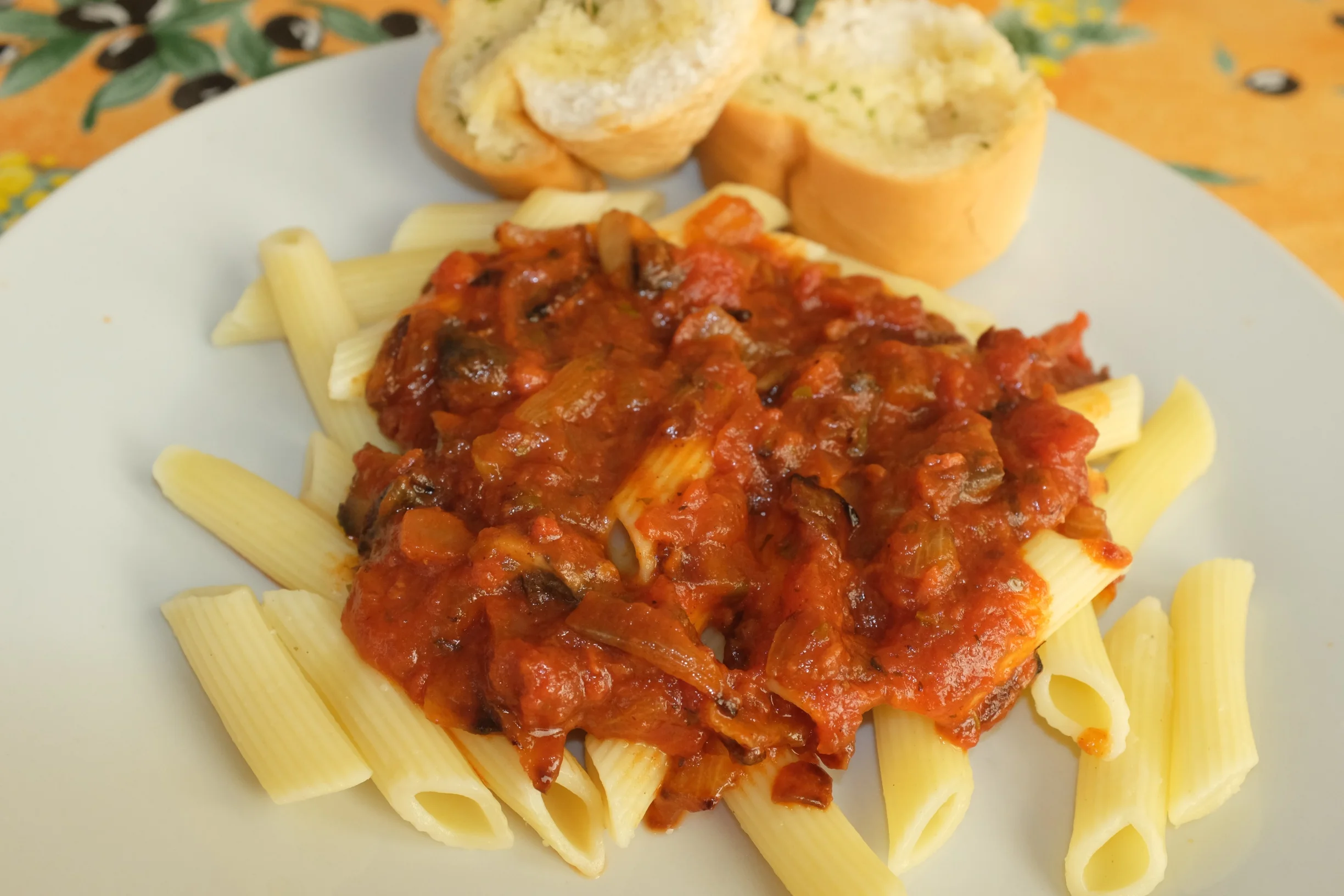 Penne pasta with sauce and garlic bread