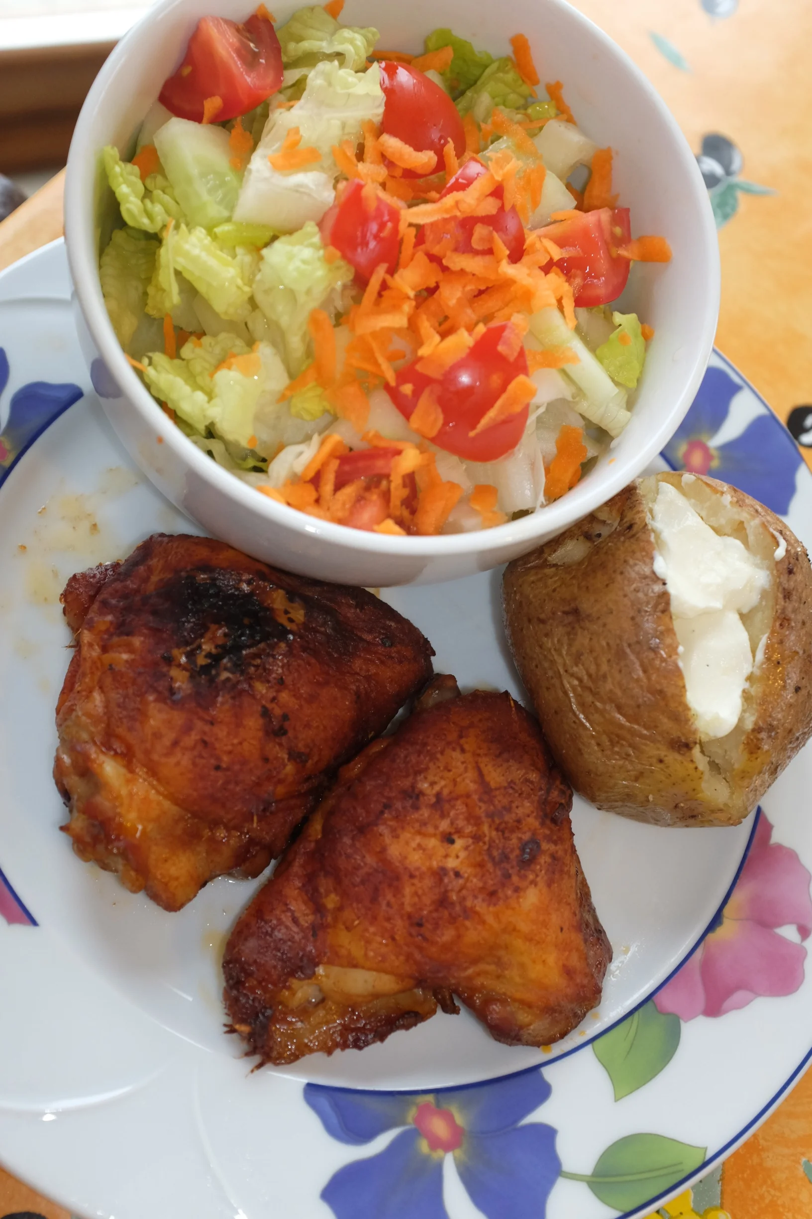 Baked marinated chicken thighs, baked potato, and a side salad