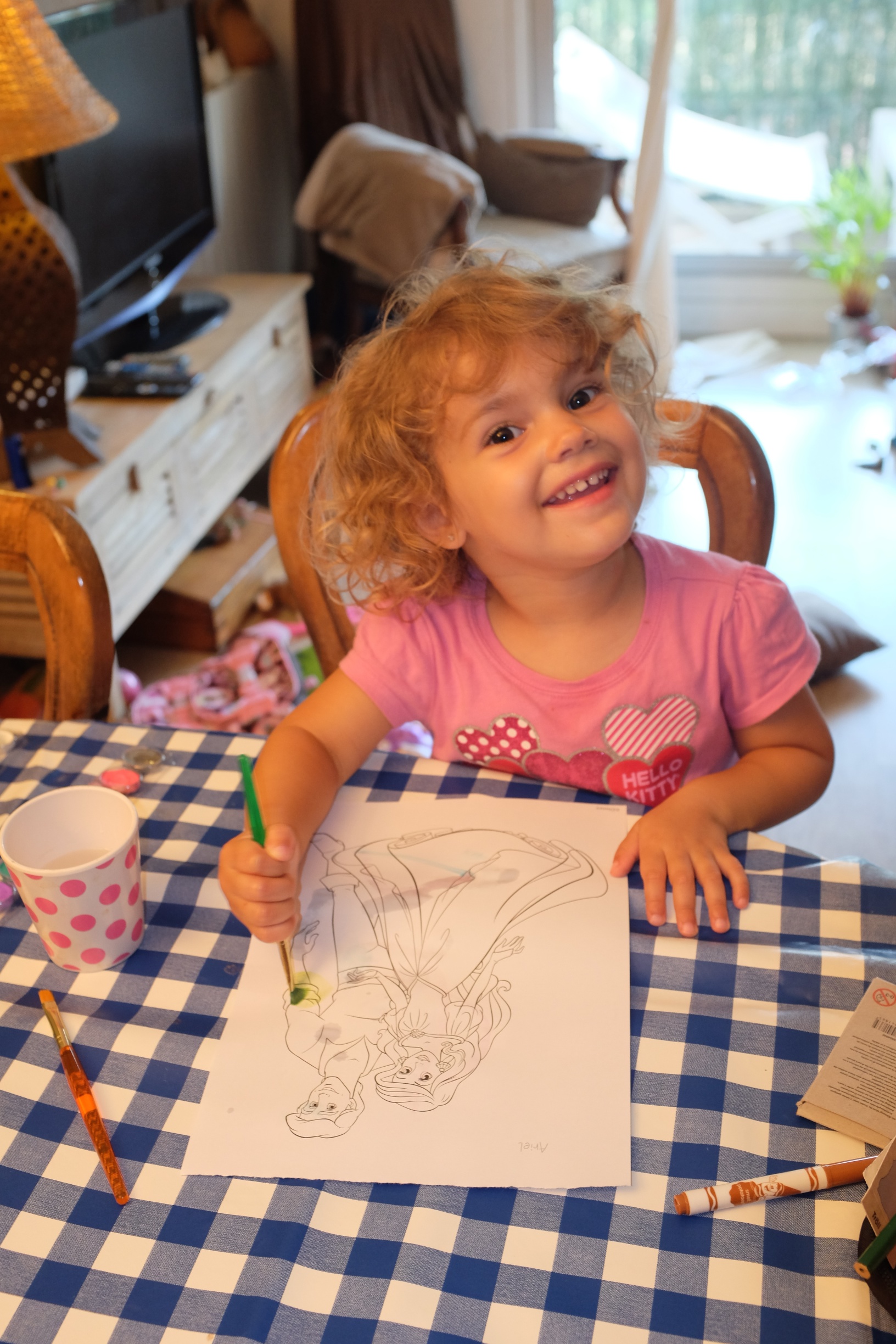 Hannah painting a picture of Ariel and Prince Eric