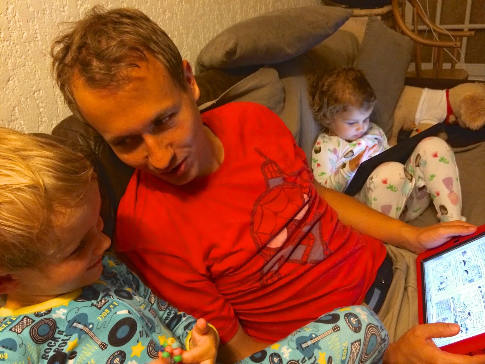 Daddy reading Kian Captain Underpants while Hannah looks through her Princess Adventures book.