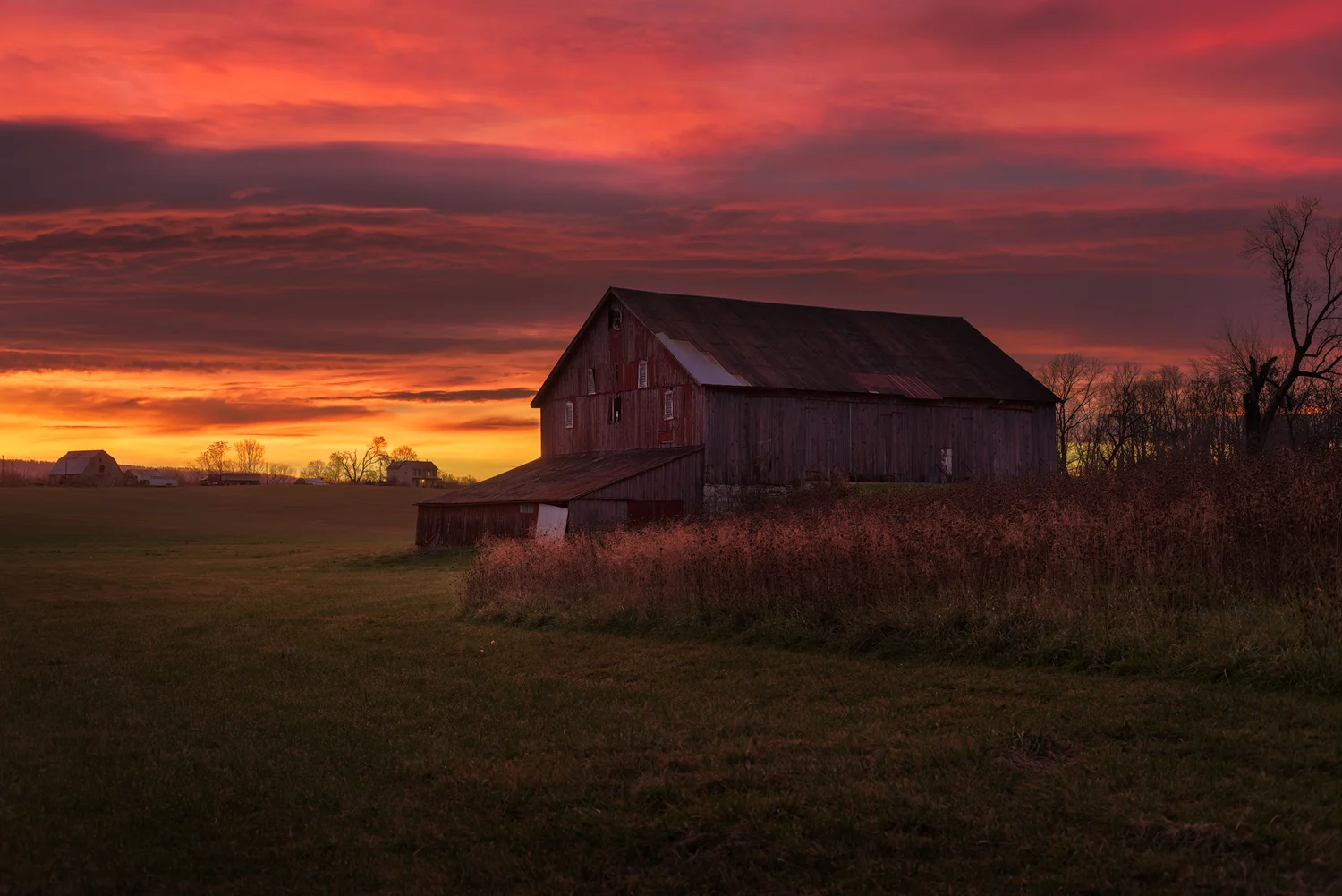 The Red Barn Glows in the Reds and Oranges of a Morning Sunrise.