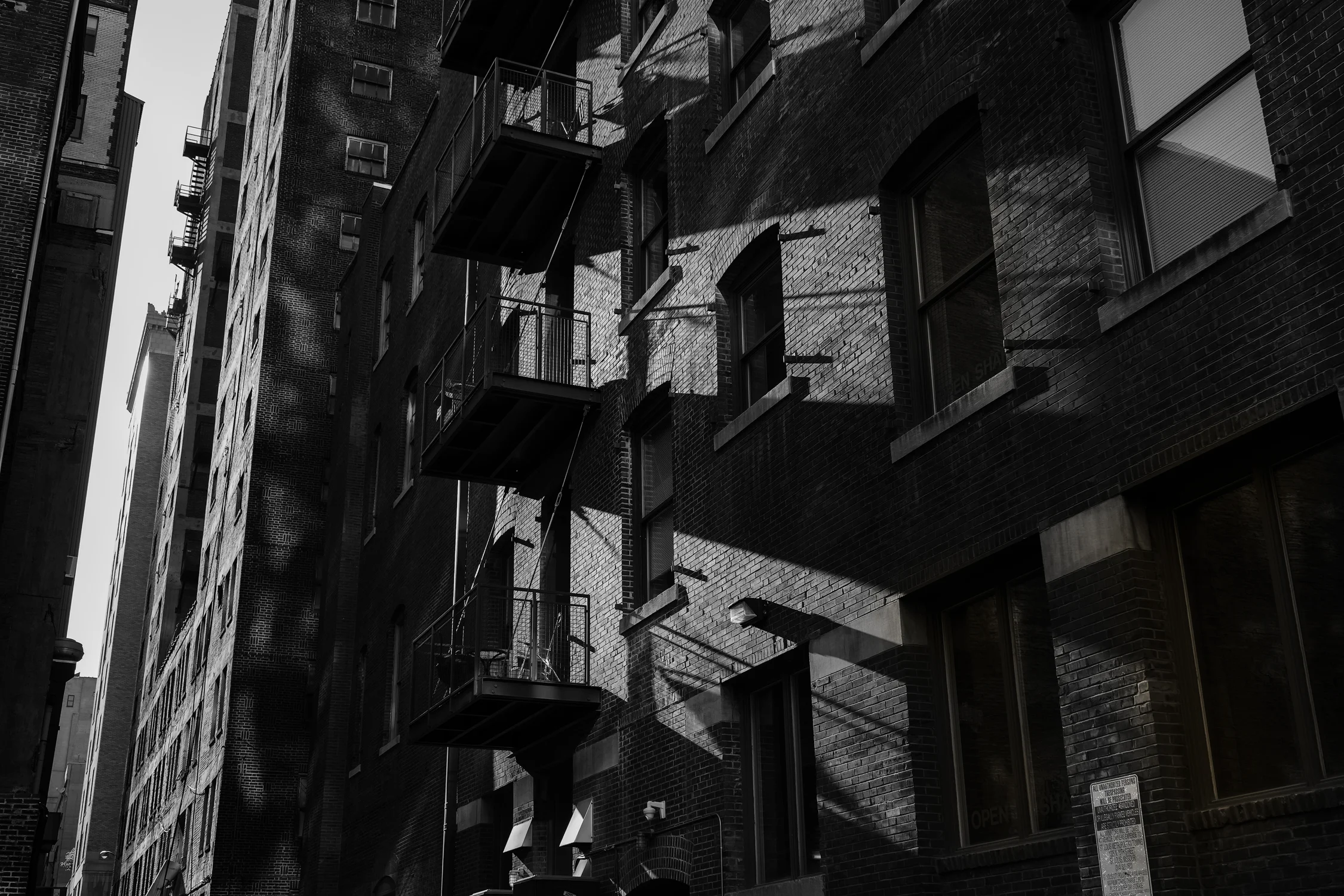 Sunlight through an open slot casts shadows on a brick facade. Fuji X-Pro 2 and a Fujinon 16-55mm f2.8.