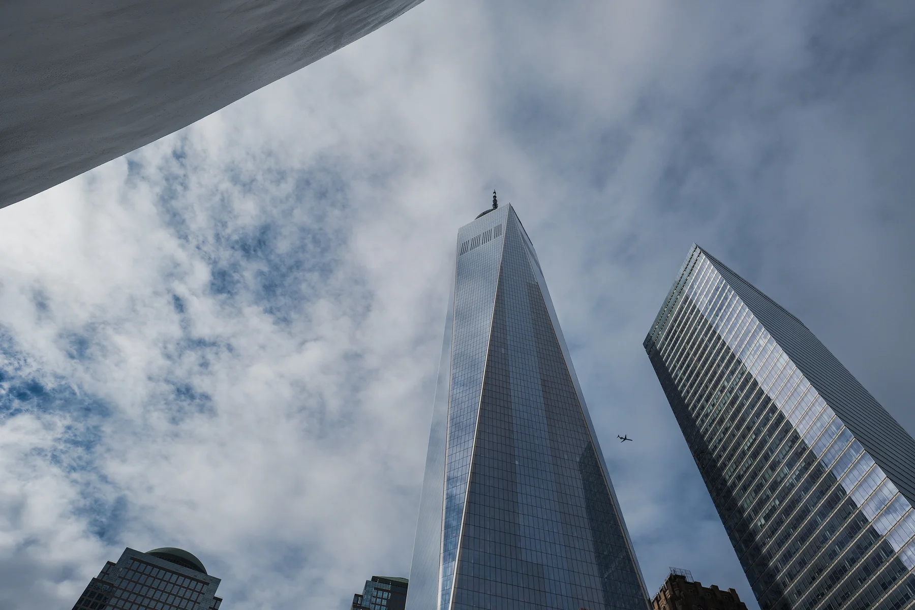 High, and far away, a plane appears between The World Trade Center and another tower.