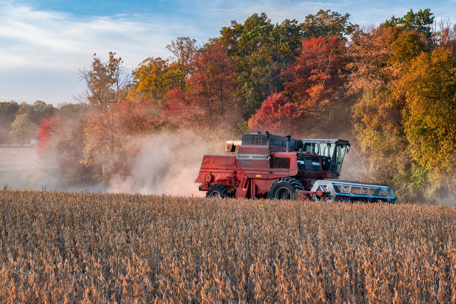 The lead combine kicks up a cloud of dust as it starts into a new row. Fuji X-T2 and a Fujinon XF55-200mm at 70mm. Image exposed at ISO 200 at f5.6 for 1/80 of a second.