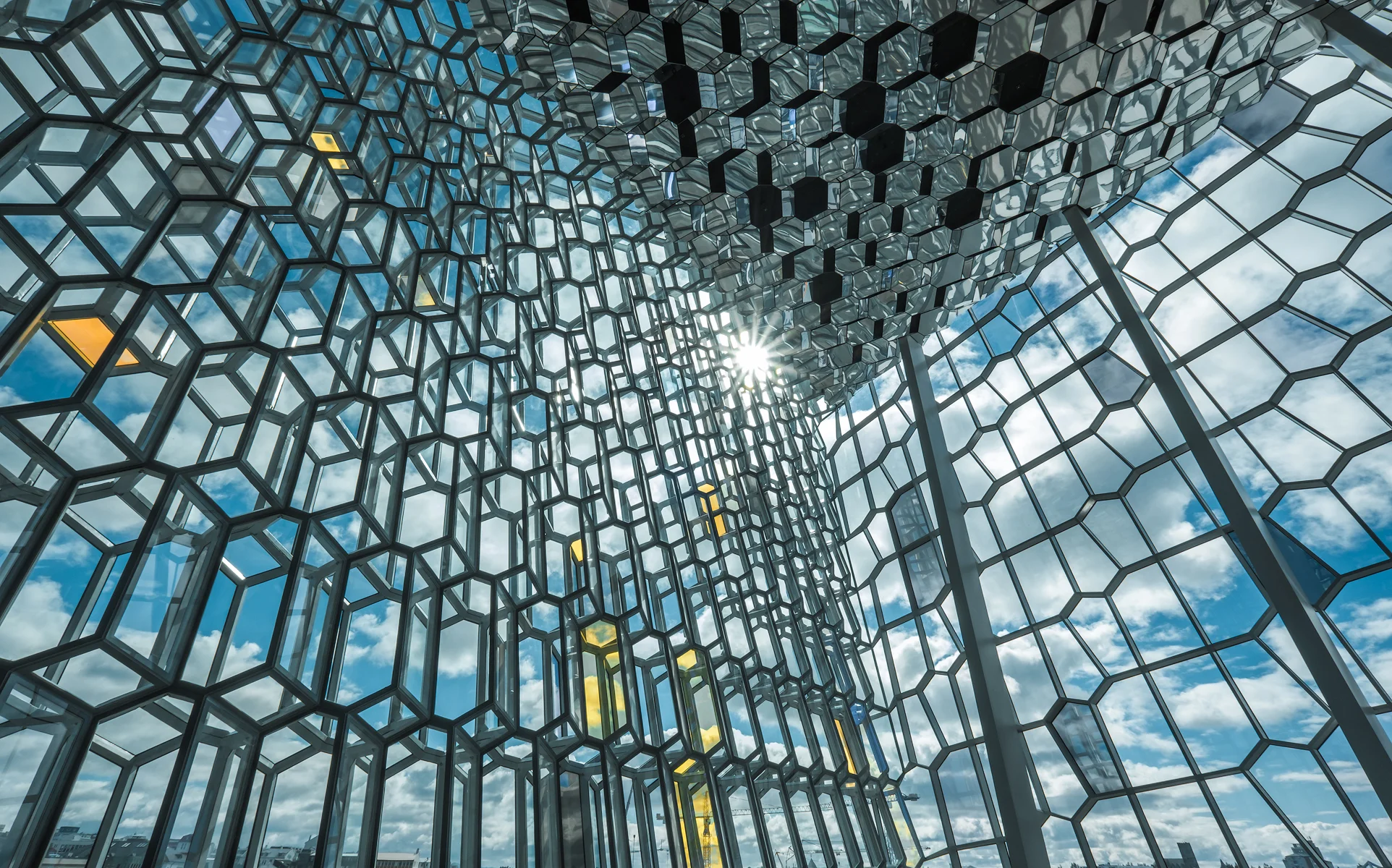 A sun star appears at the intersection of glass wall and ceiling.