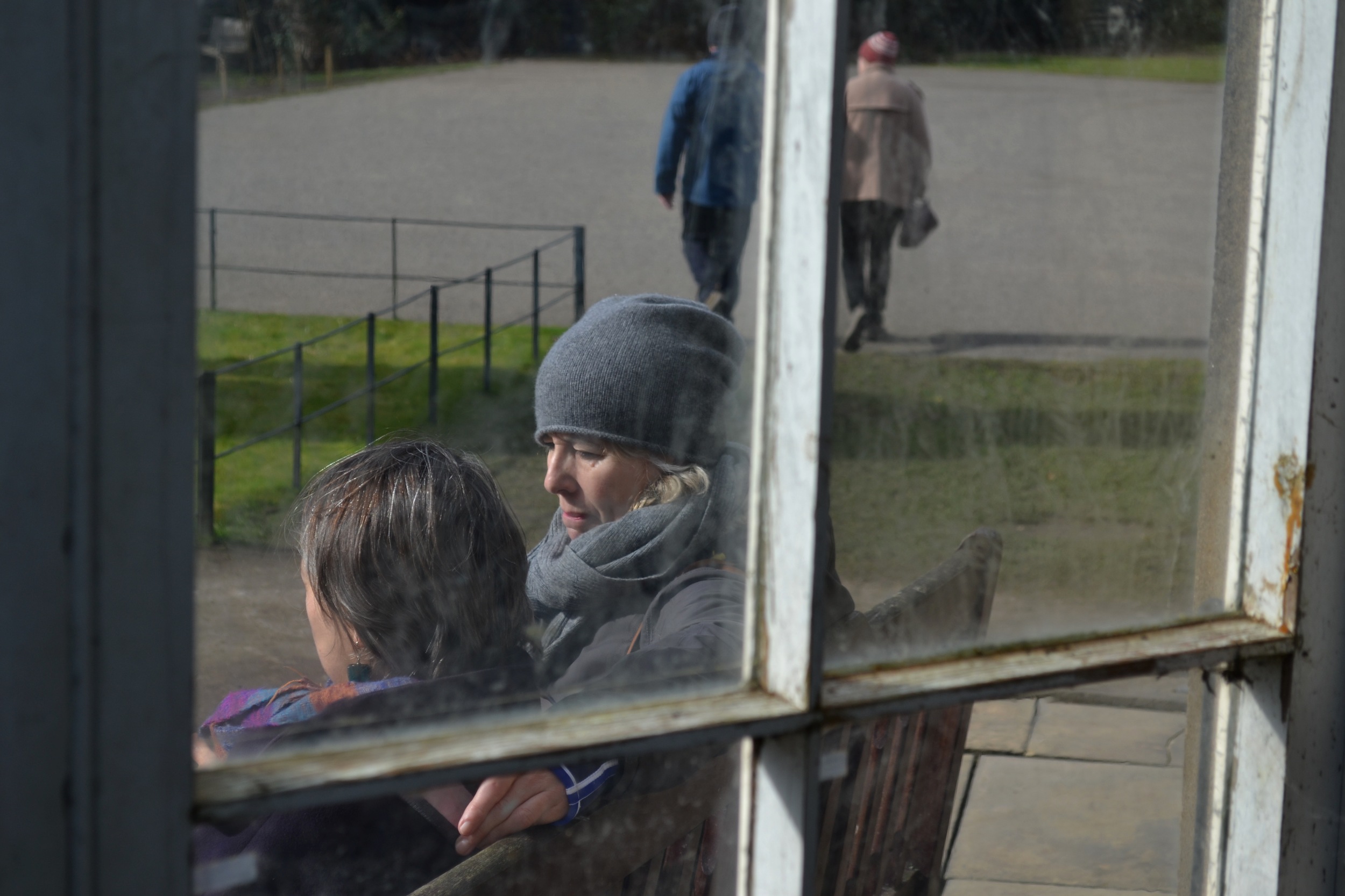 View from inside the Camellia House, Two women talking. 2015. 