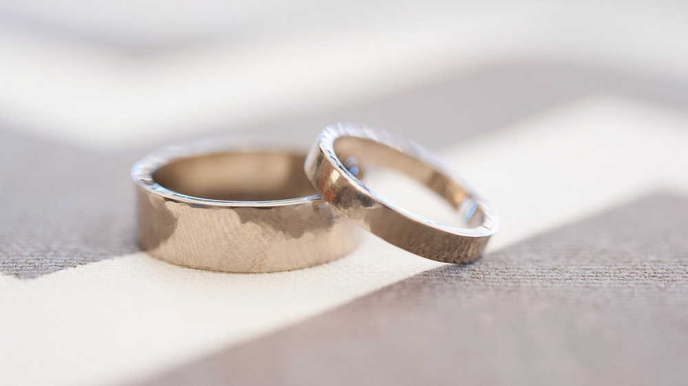 Rings by Ryan & Kristina; 5mm and 3mm flat bands in palladium white gold with a light hammered texture. Photo by Barbie Hull