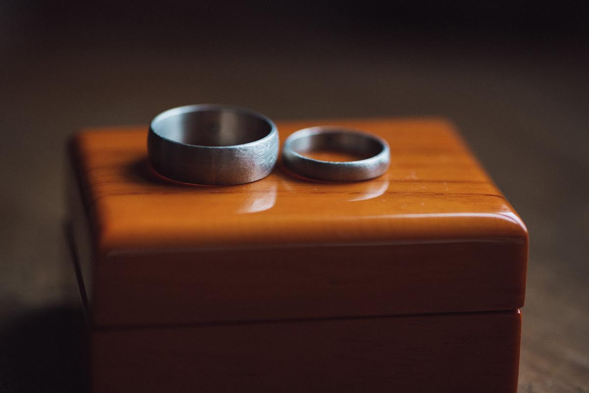Ring by Roger and Kristyn: 6mm and 4mm 14k palladium white gold bands with a rough finish and green diamonds set on the inside of each band Photo by Pawel Bebenca