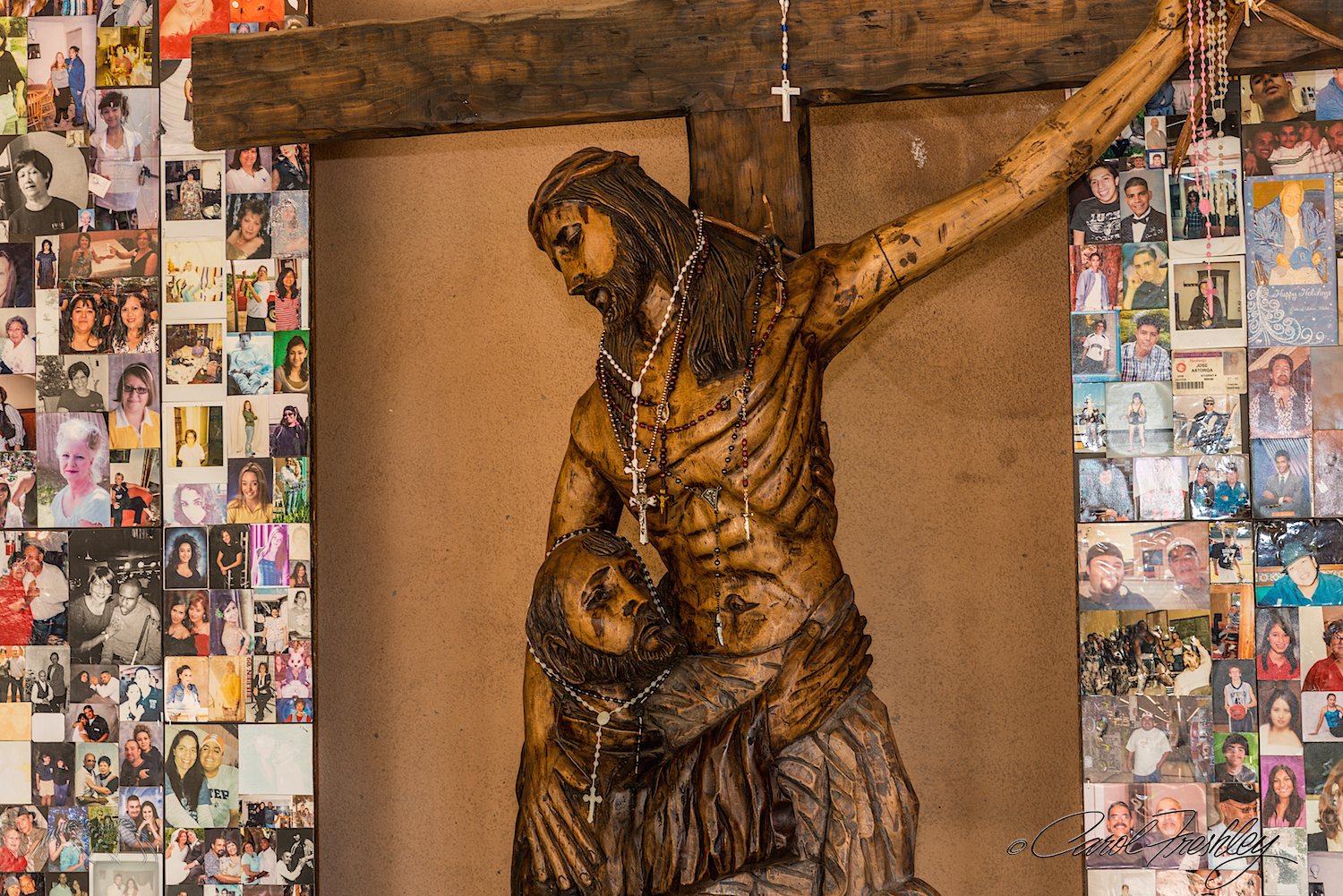 Statue in new open porch. Photos of loved ones are left on the walls with requests for prayers.