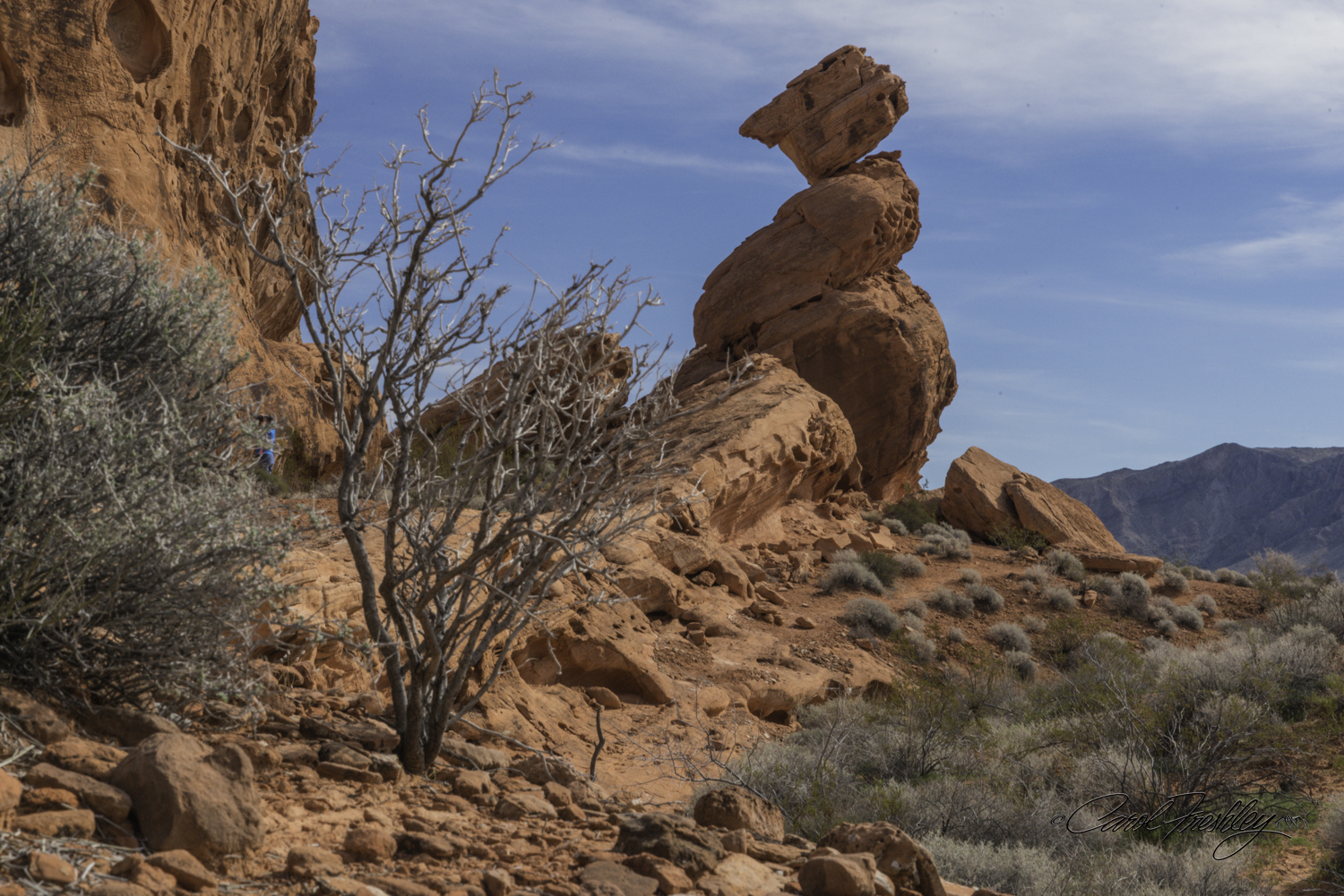 The small piece of blue on the left side is a person. Balancing rock is taller than it might look when photographed at this angle.