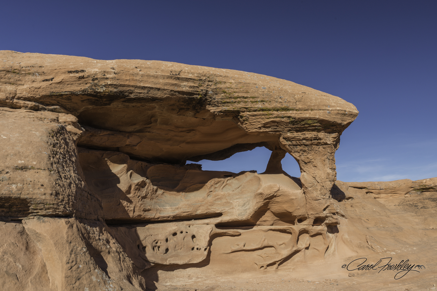 This rock formation is called 'The Piano". My mother wanted to know how big the bench was!! You can actually see this from the road. Like the Fire Arch, this rock formation only looks like a piano from one angle. This would probably be better as an early morning shot to open up the shadows underneath. Ah! So many morning shots and so few mornings! My lament (just kidding). This image requires that you move in real close to avoid a lot of scrub brush. I used a wide angle lens and crouched low to the ground to get a clear sky through the opening. Stand up and you get brown mountains in the background that sort of takes away the clean look of a plane.