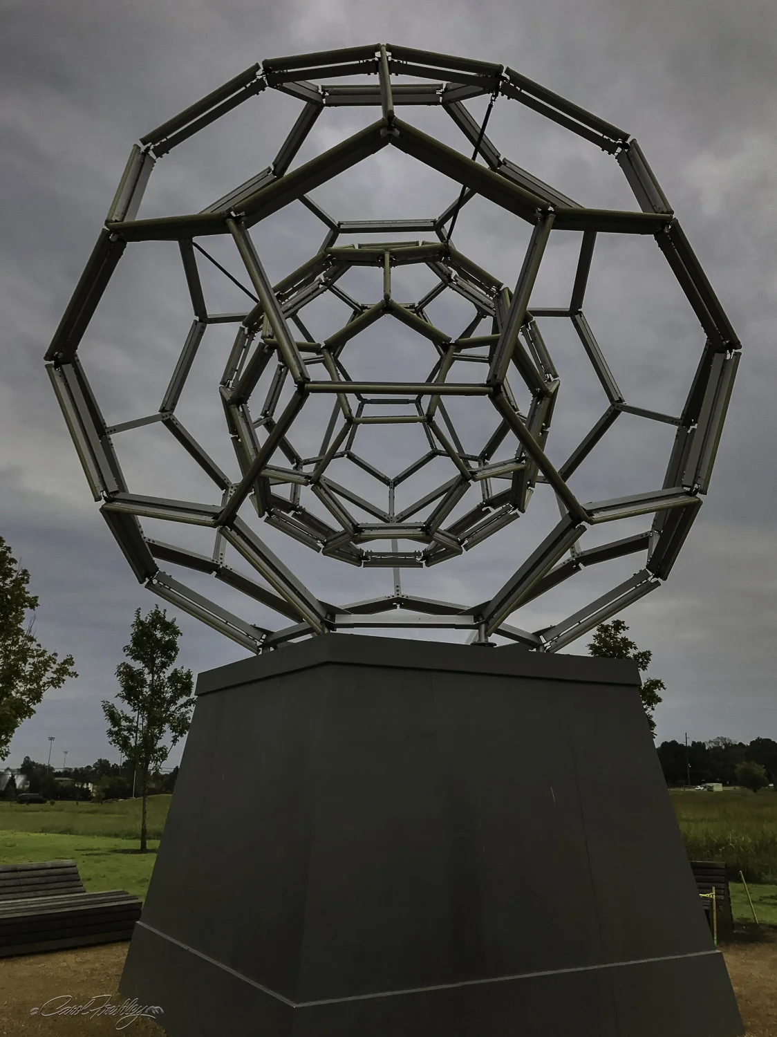 This sculpture can be seen from the street as you approach Crystal Bridges. This is ' Buckyball' , a light installation based on concepts of geometry, mathematical relationships and optical perception. The shape is called a 'geodesic sphere' or Buckyball in reference to American architect Buckminster Fuller and his futuristic dome designs. This sculpture was designed by Leo Villareal who, using a monumental scale, also explored the mathematical concept of self-similarity through the use of two identical nested spheres. We were there during the day so we missed out on the light show that 180 LED tubes containing thousands of pixels provide at night. The optical effects that are generated trigger neurological processes within the brain, such as our natural impulse to identify patterns and gather meaning from our external environment. The zero gravity benches you see invite viewers to recline while enjoying this unique and complex art experience. (Information from posted display at the site.)