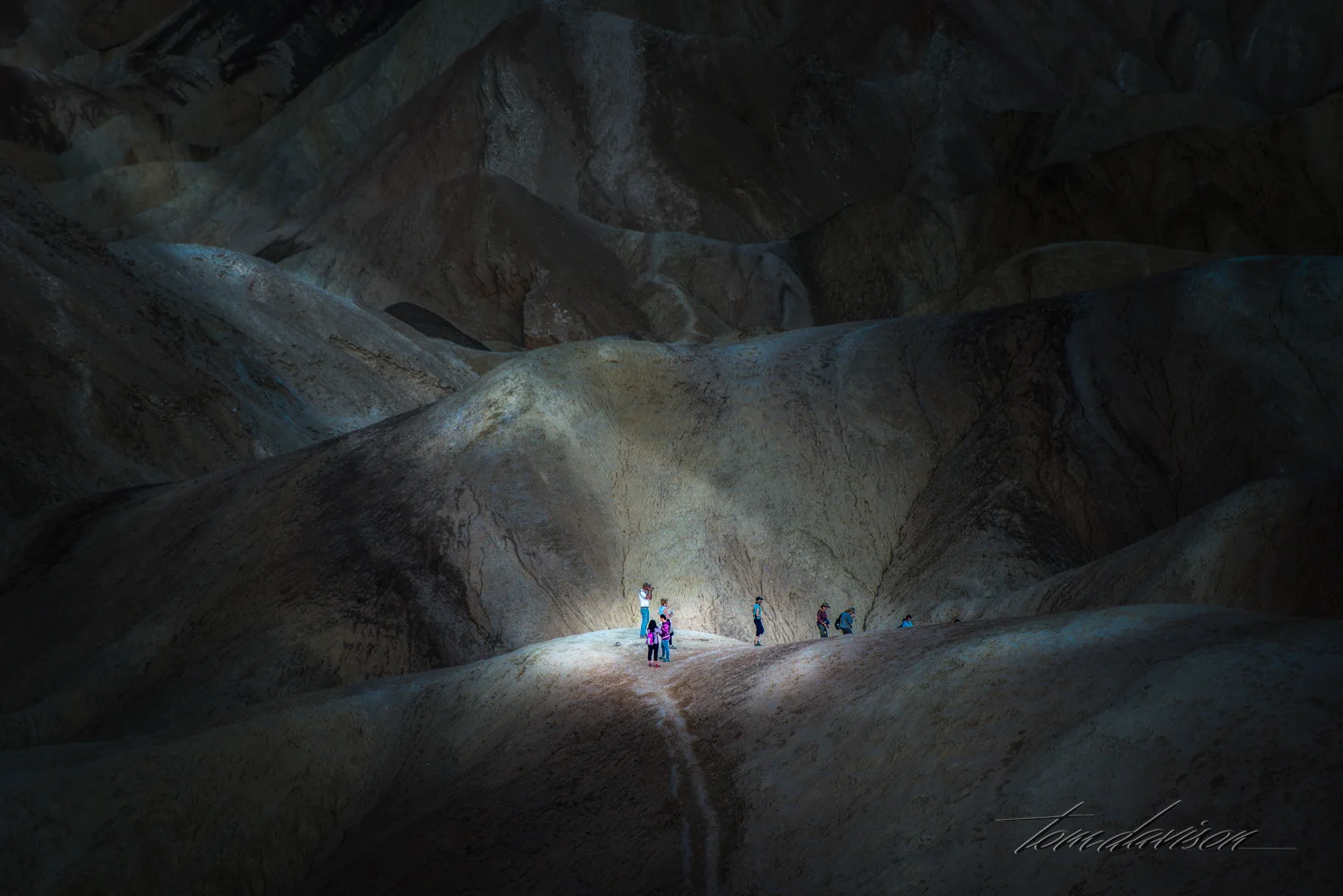 Tourists hiking among the ridges at Zabriski Point in Death Valley.
