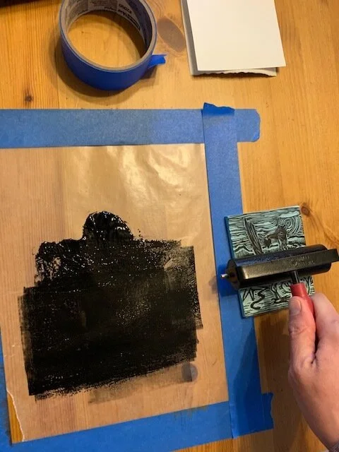 5a. Putting a dollop of ink on the wax, I push the brayer into the ink, and I want a nice, tight, high-sounding sticking noise, not a gloppy, loud smacking noise, so I don’t apply too much ink to the block. 5b. Once I have the right consistency, I a…