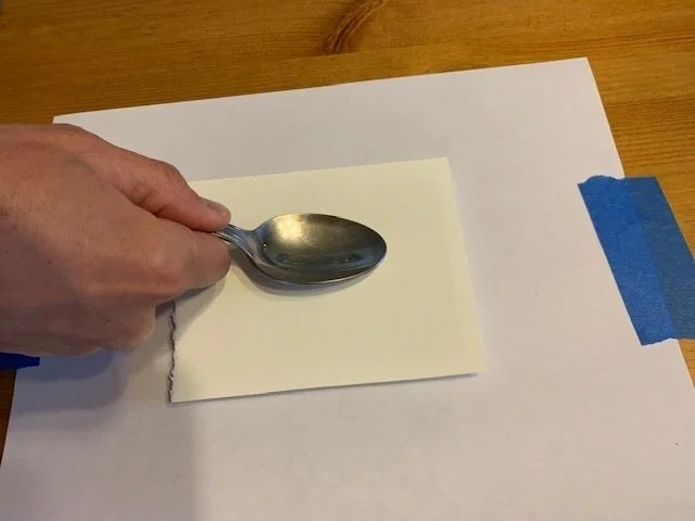 7. Next, I use my burnishing tool to “burnish” or “polish” the paper and help affix the ink to the paper. I use pressure to make sure I’m getting all the details without smudging or smearing the design.