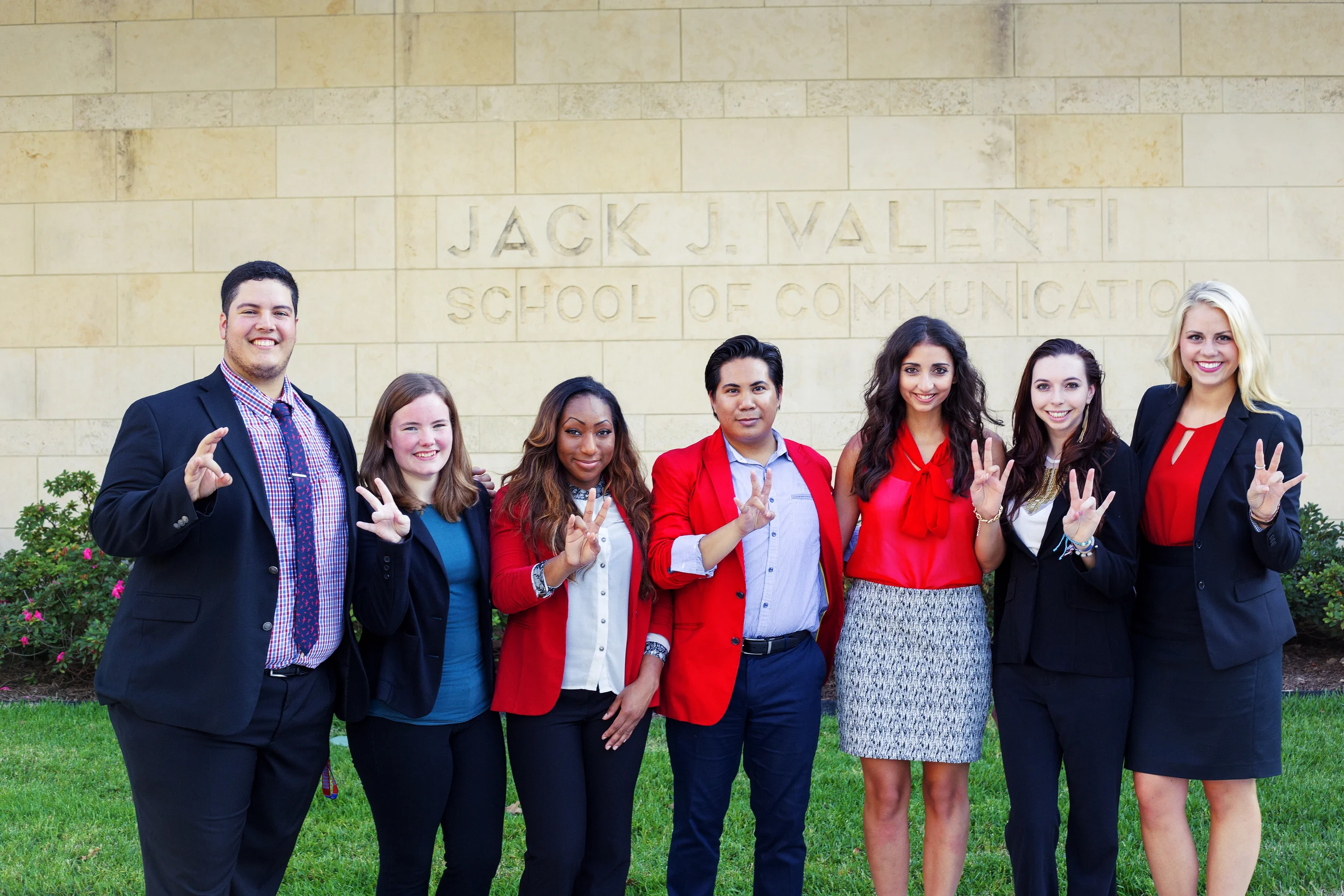 (L to R) Kevin Arevalo, Chancie Price, Alexis Culver, Gemrick Curtom, Christina Nemry, Caroline Alvarez and Angela Austin pose in front of the Jack J. School of Communication.