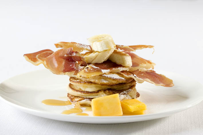 Crispy Pancetta on a bed of pancakes, topped with banana & syrup