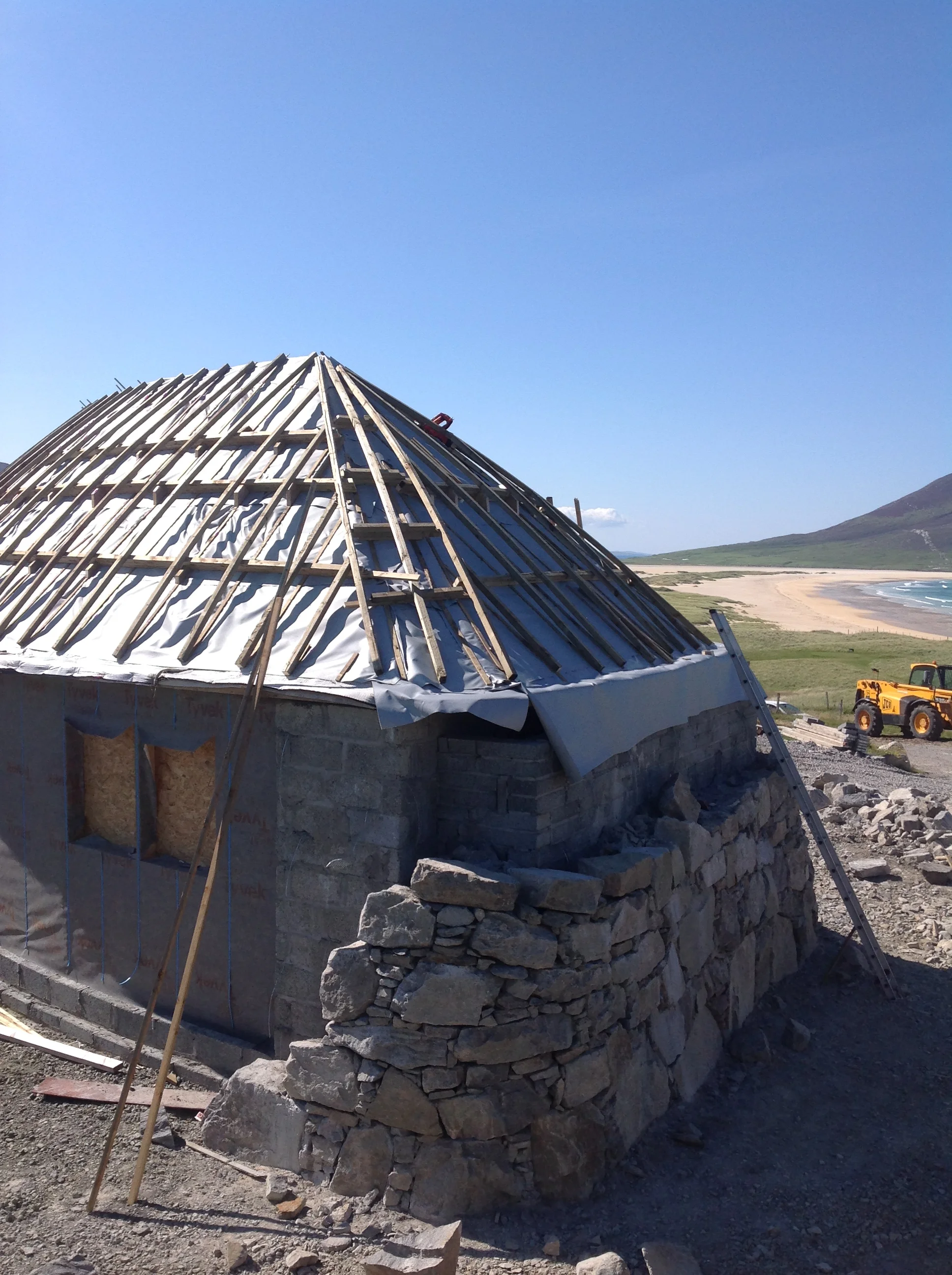 Battens in place ready for the turf that goes under the thatch - and the beginning of the stonework 