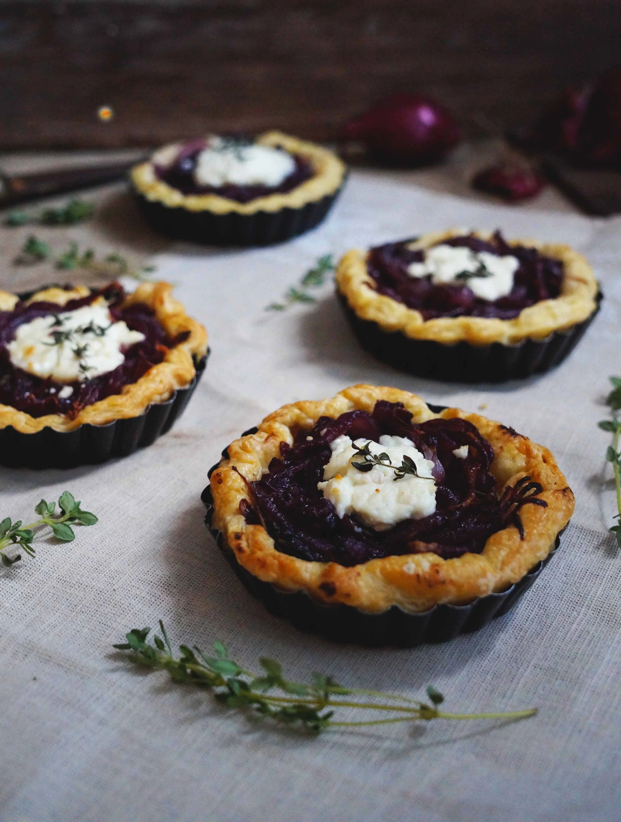 Tartelettes met gekarameliseerde ui, geitenkaas & tijm