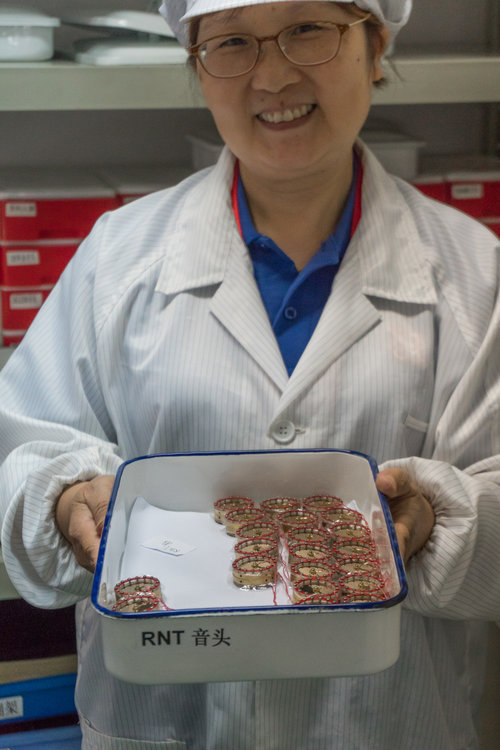 sE's Capsule Master Hongzu Xu holding a tray of RNT capsules, hand-made in our own capsule room.