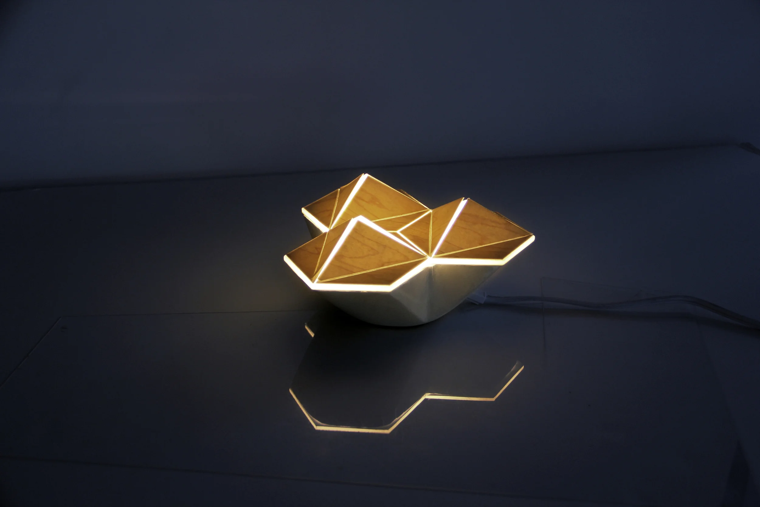  Through the sandblasted glass diffuser, heat from the bulb expands the perforated plastic laminate wood veneer on the surface. Overtime the heat allows the veneer to open up, allowing light to slowly grow out of the vessel. When turned off and allow