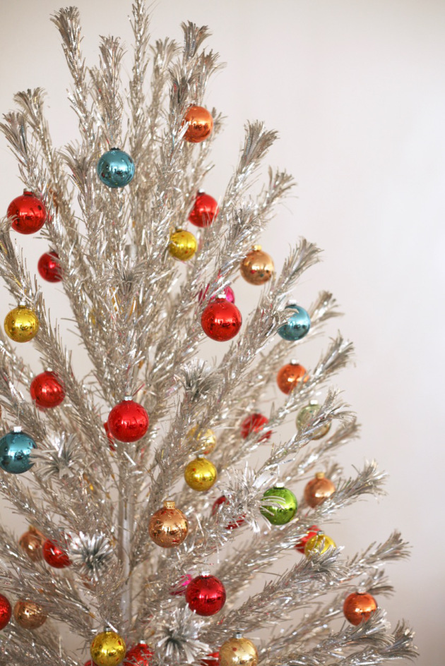 And last but not least, the aluminum Christmas tree! I picked up one of these a few years ago at an antique market. They are super fun to decorate with bright glass ornaments like the one pictured here. And fortunately they don't need lights since they are sparkly on their own (but you can't use them anyway since it's a fire hazard). Image via Suburban Pop