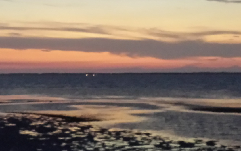 In the scene that the camera captured the horizon merged with the dark part of the bay.