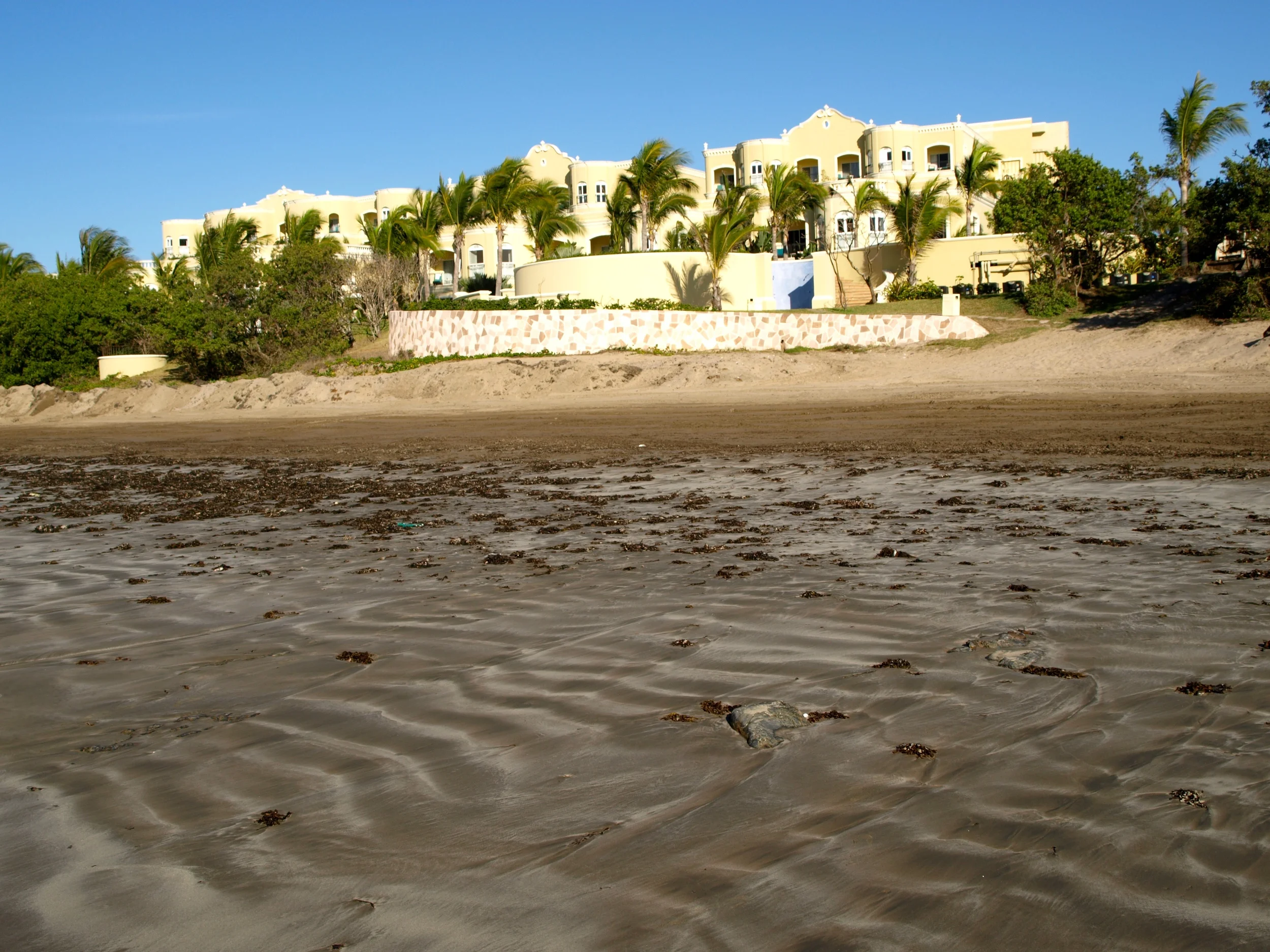   The soothing yellow color palette against stark, whitewashed walls strikes the perfect contrast against the startlingly big blue Mexican sky. 20 acres of lush green gardens and palm trees surround the estate with a stream stocked with bright orange