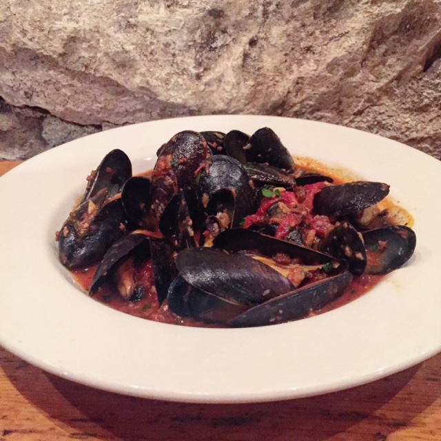 Mussels in a spicy red sauce against the back drop of a cellar wall that housed one of the original Gold Rush Mines. 