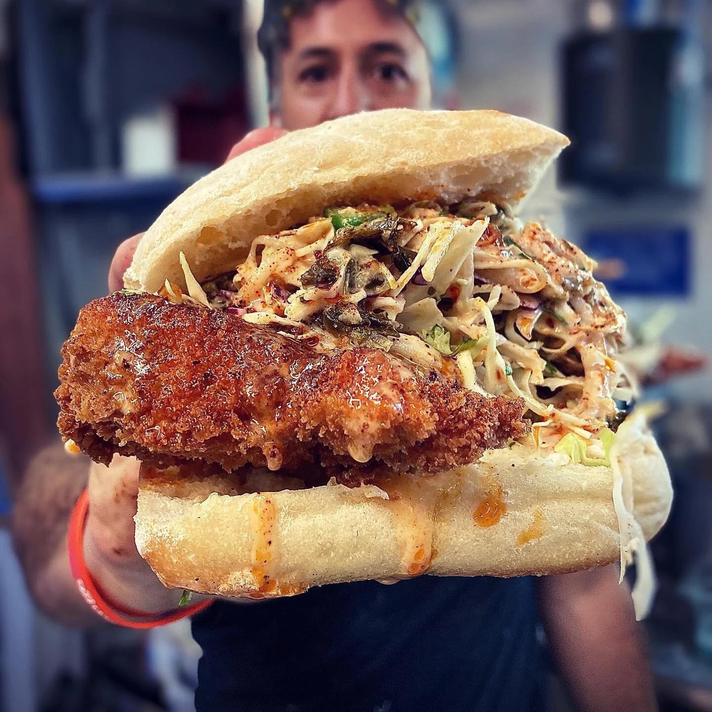 Fried chicken cutlet drizzled with spiced peanut oil, dusted w/a toasted sichuan peppercorn chili lime shake, topped with pickled dino kale papaya cabbage slaw w/a roasted peanut garlic dressing. On a panorama filone bun. Come get one for dinner! #lo