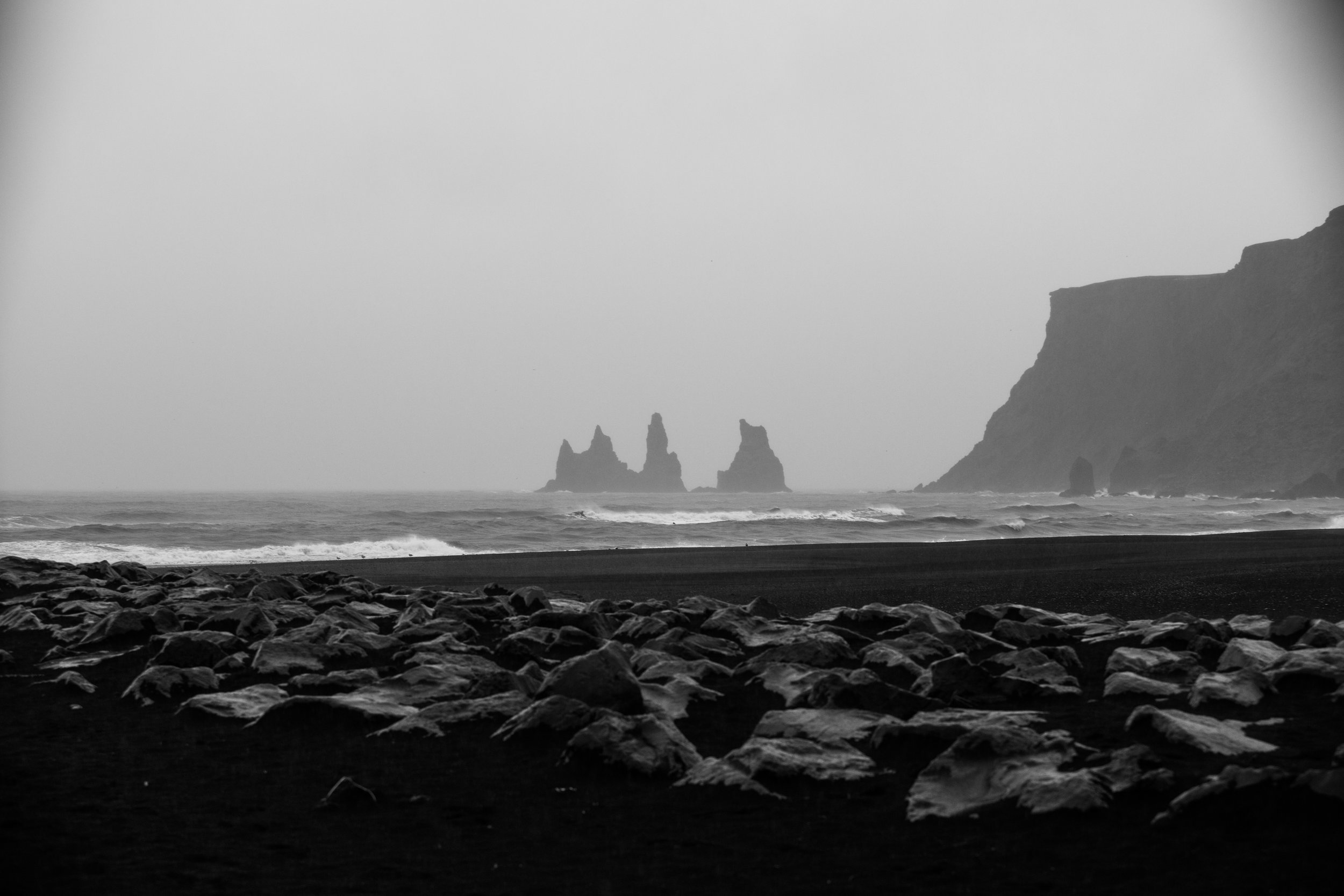 The small coastal town of Vik met us with heavy rain, the air smelling faintly of wet ash. Wind made salt crystals settle in any crevices not tightly wound in rain gear. The towers in the distance are named Reynisdrangar; formed of ancient basalt deposits in the area. Nordic folklore says two trolls tried to drag a ship to land one murky night, but were turned to stone when sunlight hit them, trapping them here indefinitely. The entirety of the beach is a fine black sand chilly paradise from the vast swathes of volcanic ash spilled at the edges of much the Icelandic coasts. 