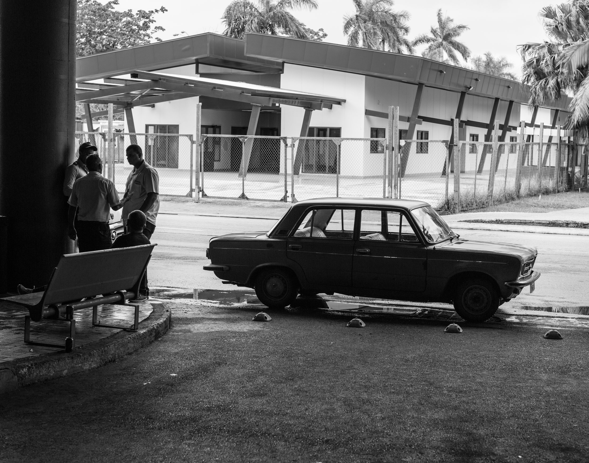 Cab drivers have a smoke while waiting near terminal 3 at Havana's José Martí International Airport with a Russian made classic.