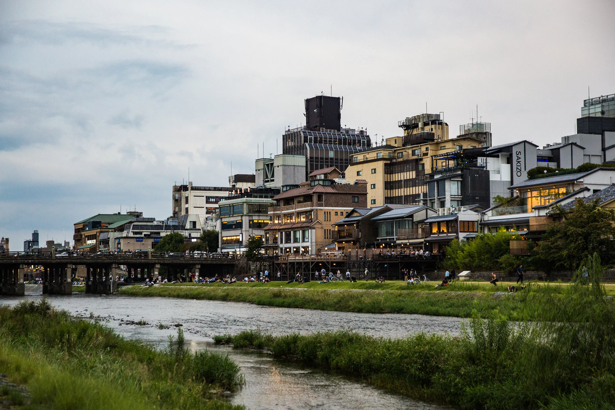 Locals and tourists alike enjoy the riverbank before making their way to Pontocho Alley for shopping, food, and sightseeing.