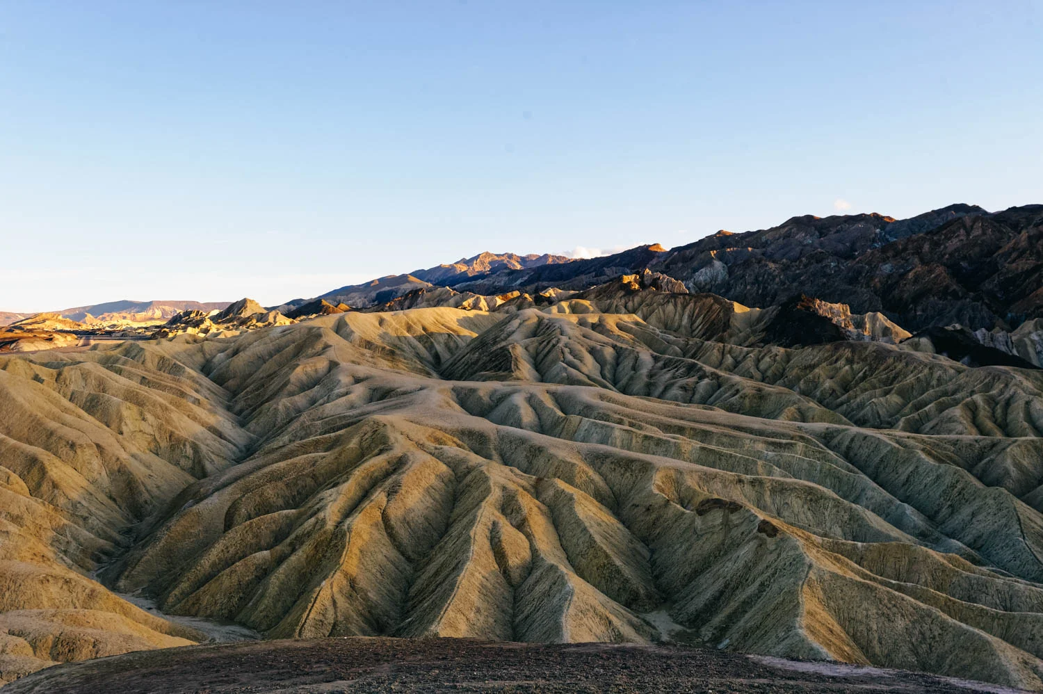 Zabriskie Point is the Delicate Arch of Death Valley National Park and people gather there at sunset. Being only 15 minutes away from the main Furnace Creek area by car, it is undeniably one of the most popular spots. It is only a 0,1 mile hike up a steep paved path to the viewpoint. Bring warm clothes if it is cold, it can get crazy windy there.