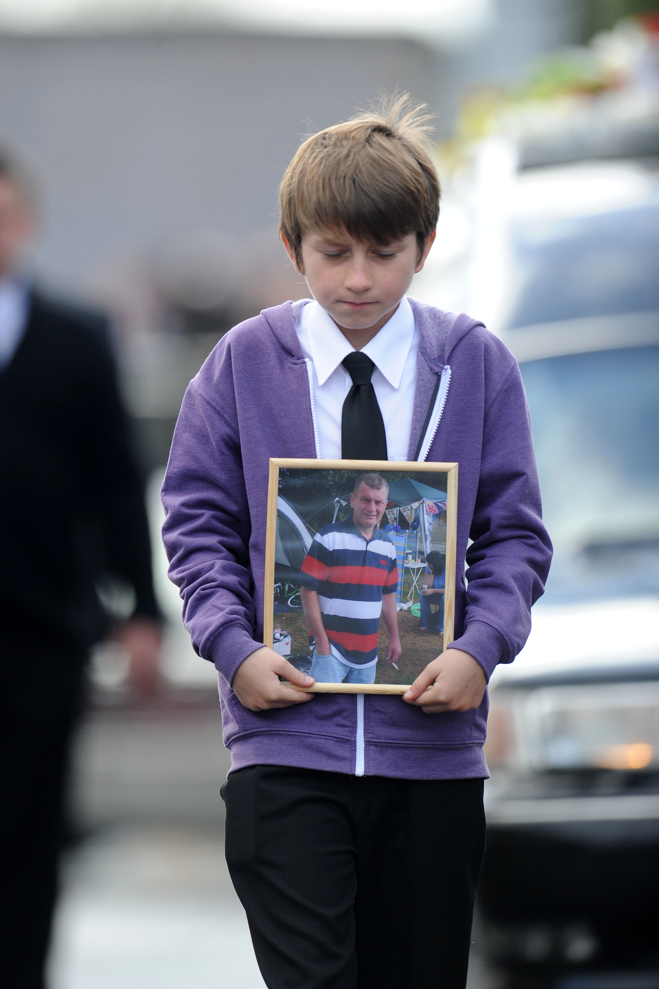  061011

Funeral of David George Powell of Godre'rgraig. One of the miners killed in the Swansea Gleision pit colliery disaster.

Picture shows son Korie carrying a picture of his father.

PIC: Matthew Horwood / Media Wales

- 