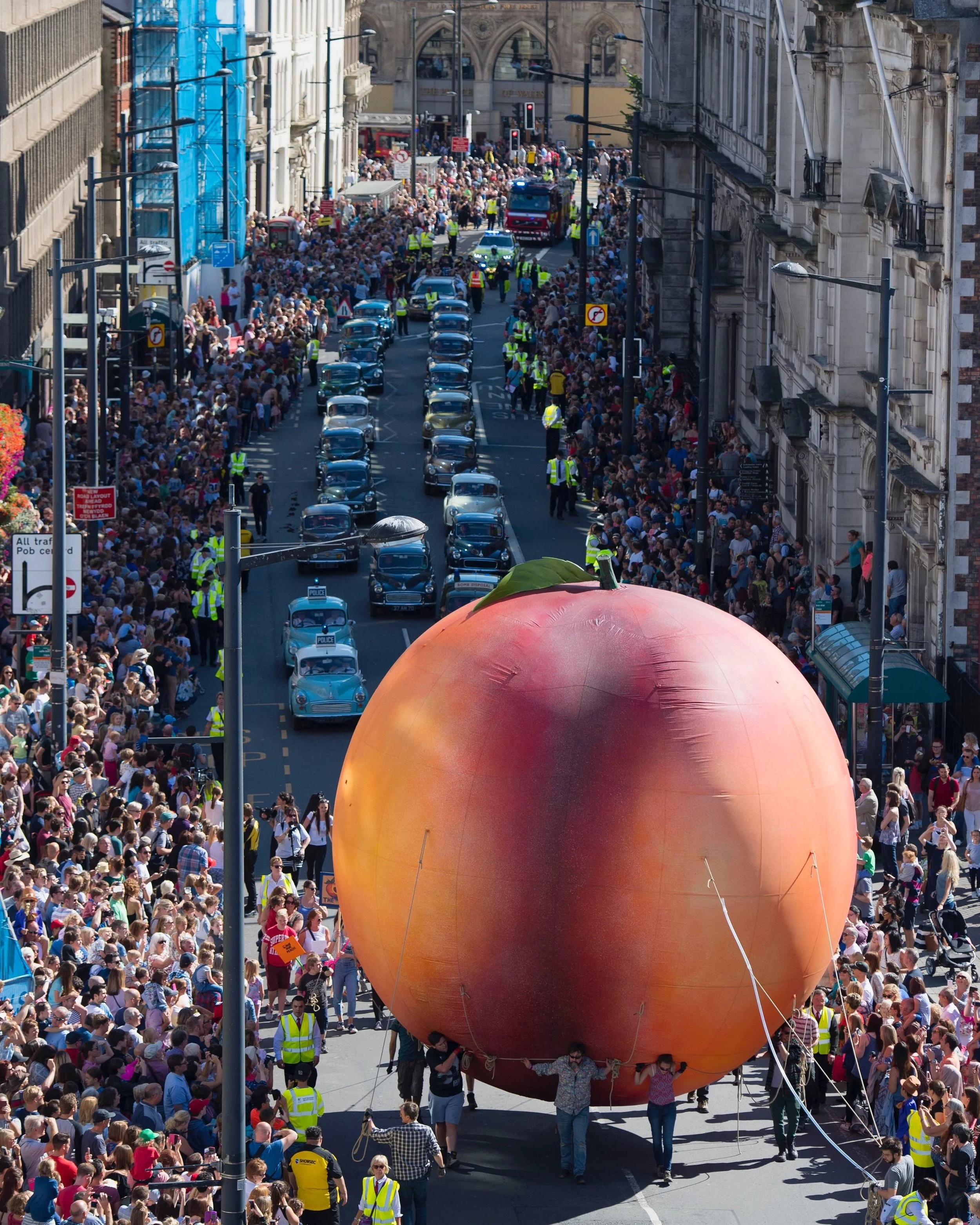 A giant peach makes its way down Westgate Street in Cardiff, South Wales during the Roald Dahl City of the Unexpected event.