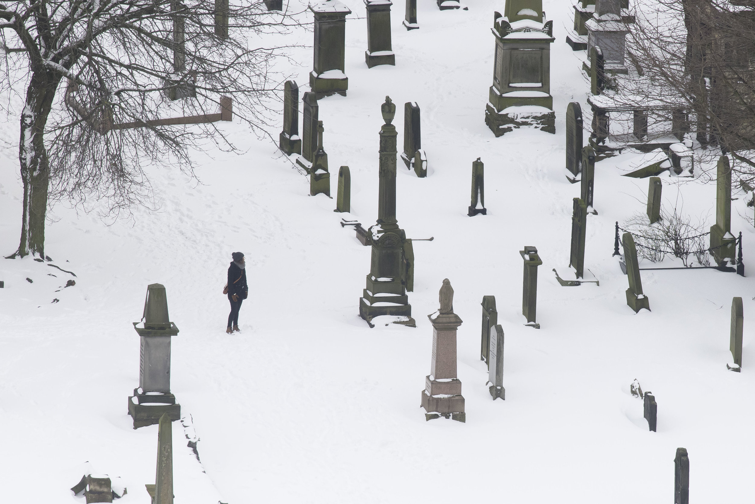  EDINBURGH, SCOTLAND - MARCH 1: A woman walks through a graveyard at Cannongate Kirk Church following heavy snowfall on March 1, 2018 in Edinburgh, United Kingdom. People have been warned not to make unnecessary journeys as the Met office issues a re