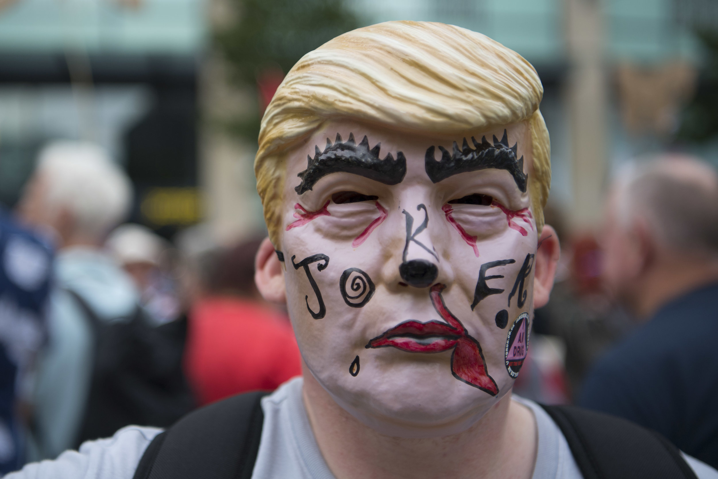  CARDIFF, UNITED KINGDOM - JULY 12: A man is seeing wearing a Donald Trump mask as protestors gather outside Cardiff Library on the Hayes in Cardiff to protest against a visit by the President of the United States Donald Trump on July 12, 2018 in Car