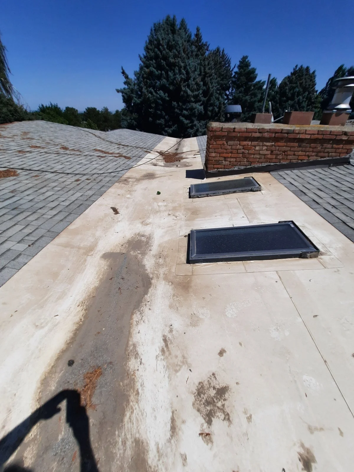 Worn and stained low-slope roof section with skylights before recoating, Kennewick, Washington