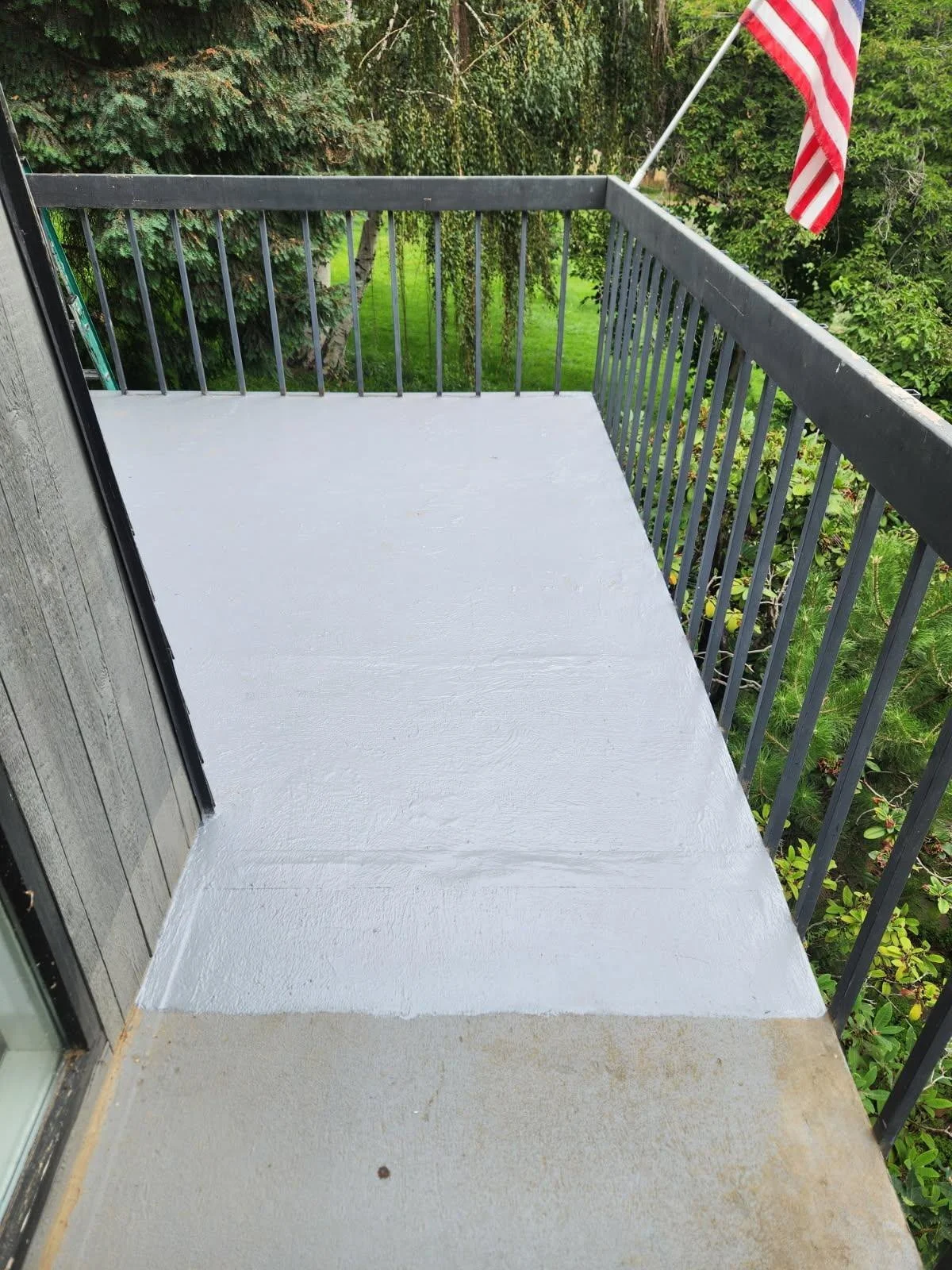 Finished white waterproof deck coating on a residential balcony in Kennewick, Washington