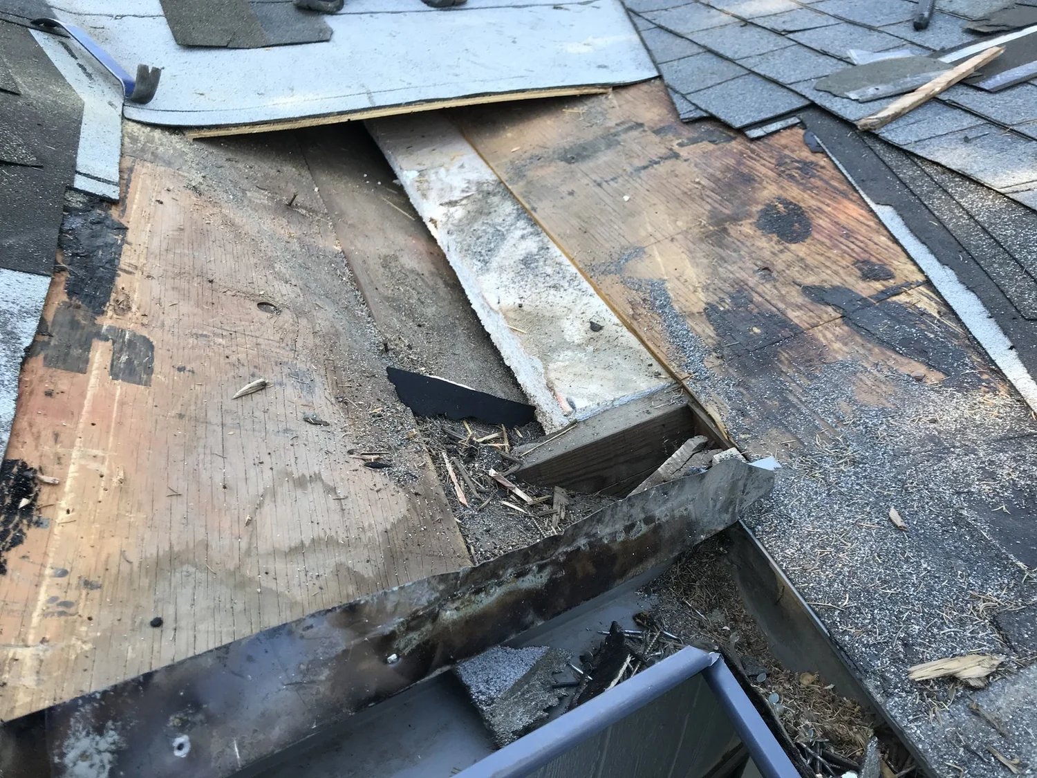 Roof tear-off revealing rotted and delaminated decking that had to be replaced before the new roof went on
