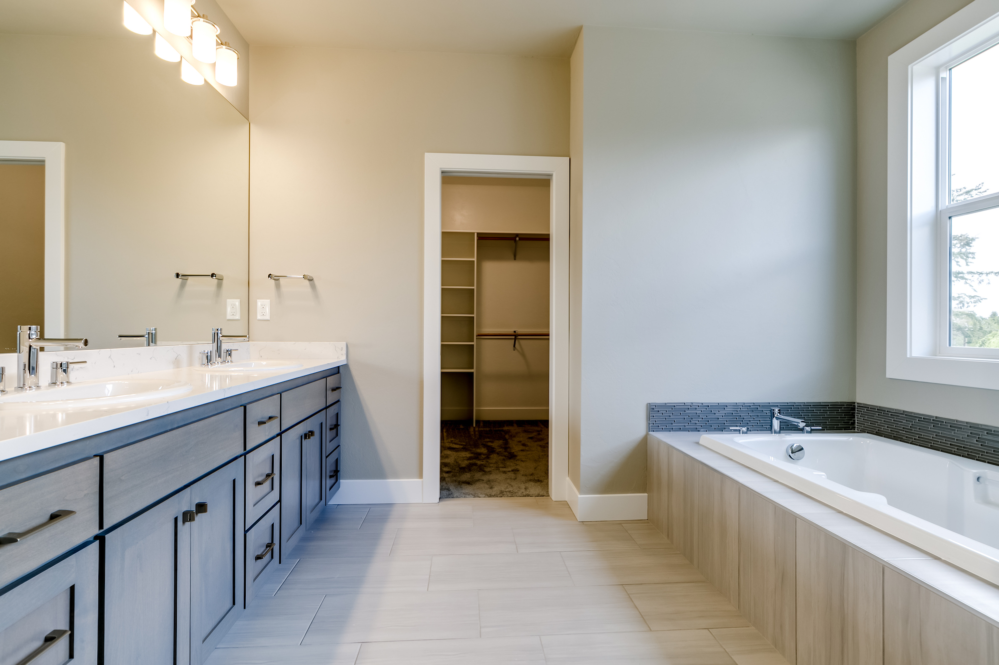 This master bathroom includes a soaker tub, 2 headed custom shower and walk in closet.