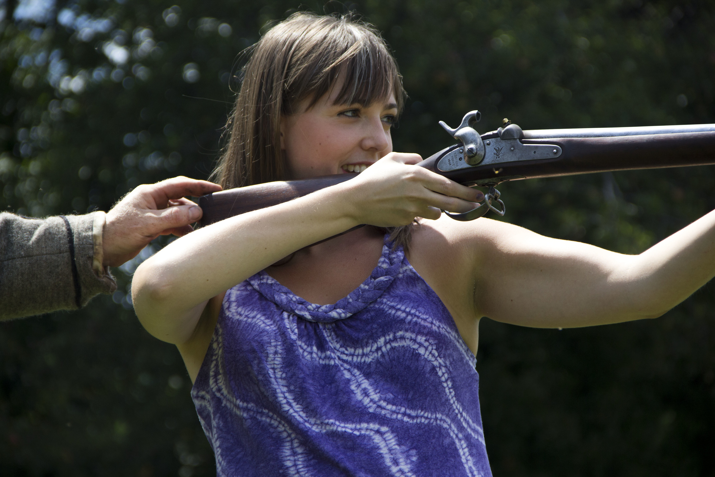 She looks cool here, but her original handling of this thing prompted the owner of the gun in question to say, "No, no, don't hold it like a bazooka."