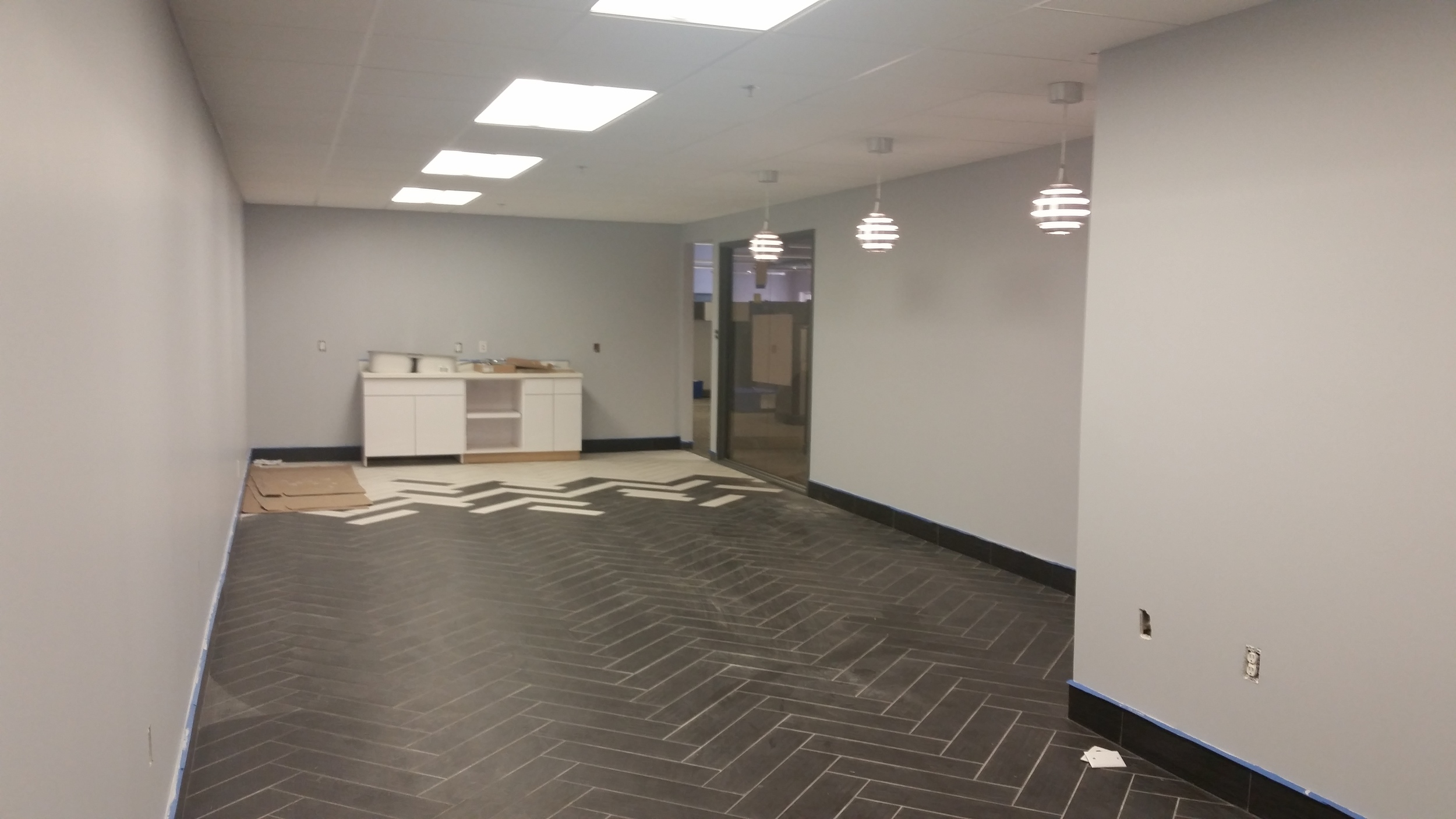Break room mill work has started and pendant lights are hung.