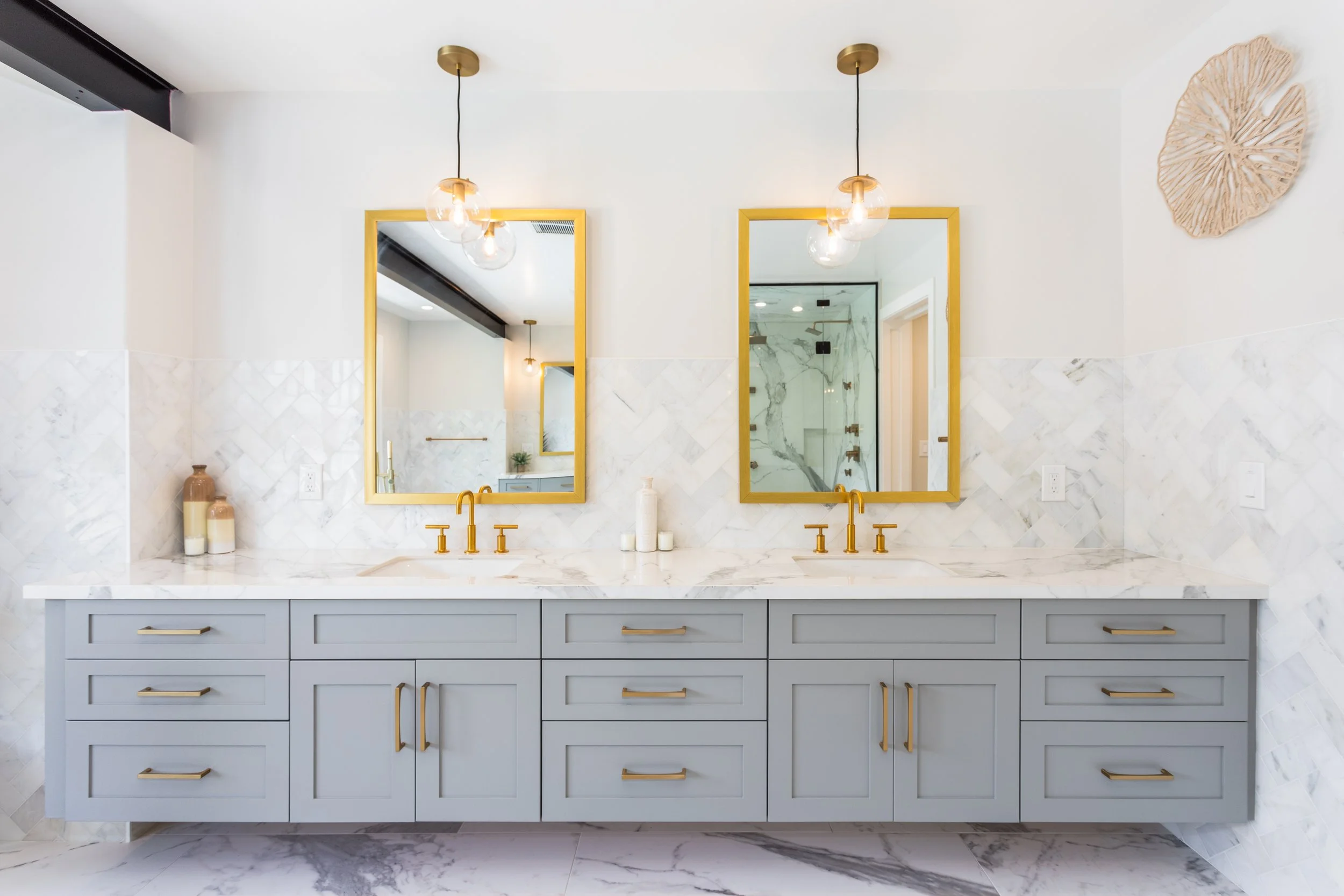 Beautiful custom bathroom with gold mirrors and gray cabinets