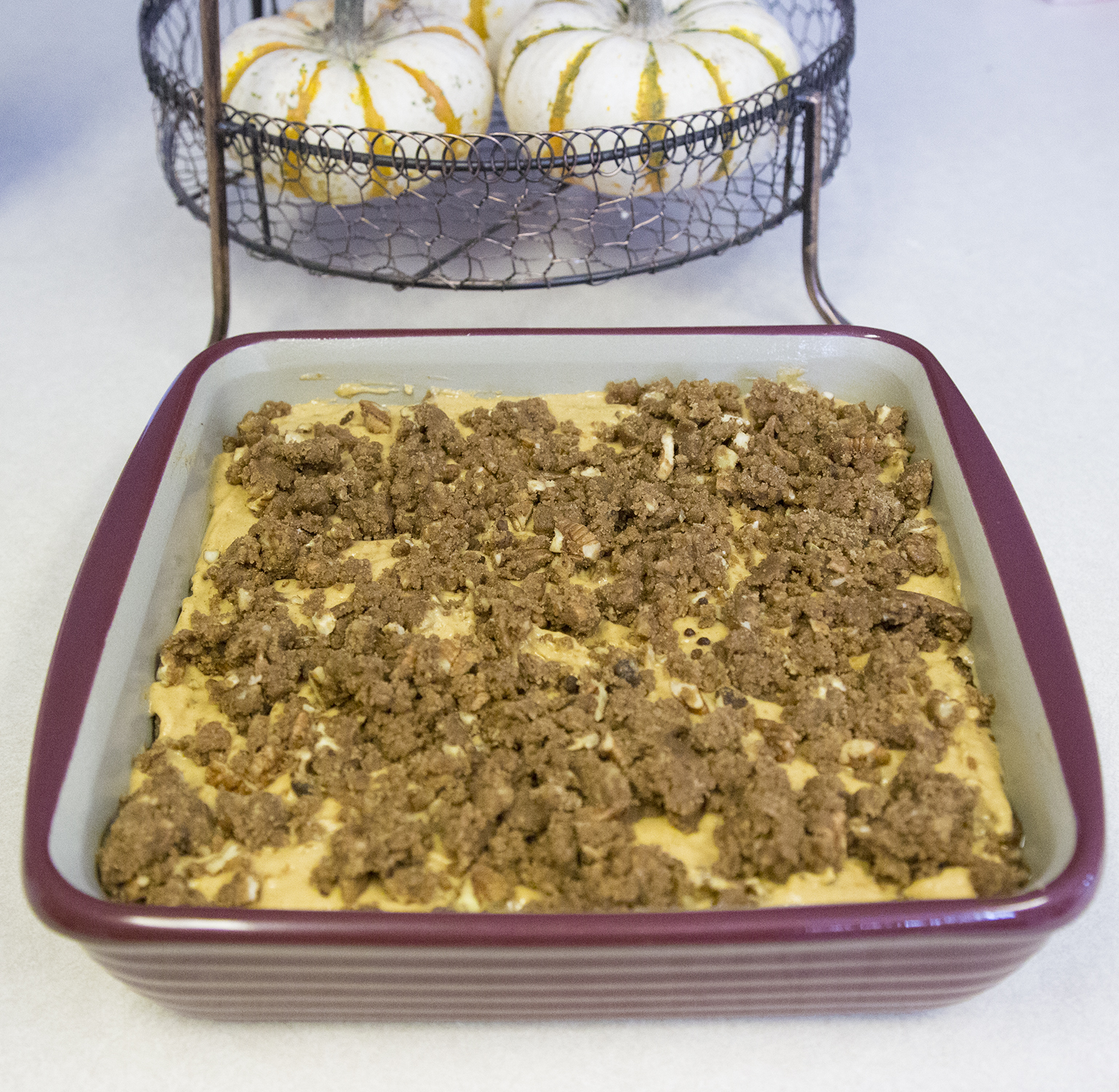 Batter in the pan with crumble mixture layered in