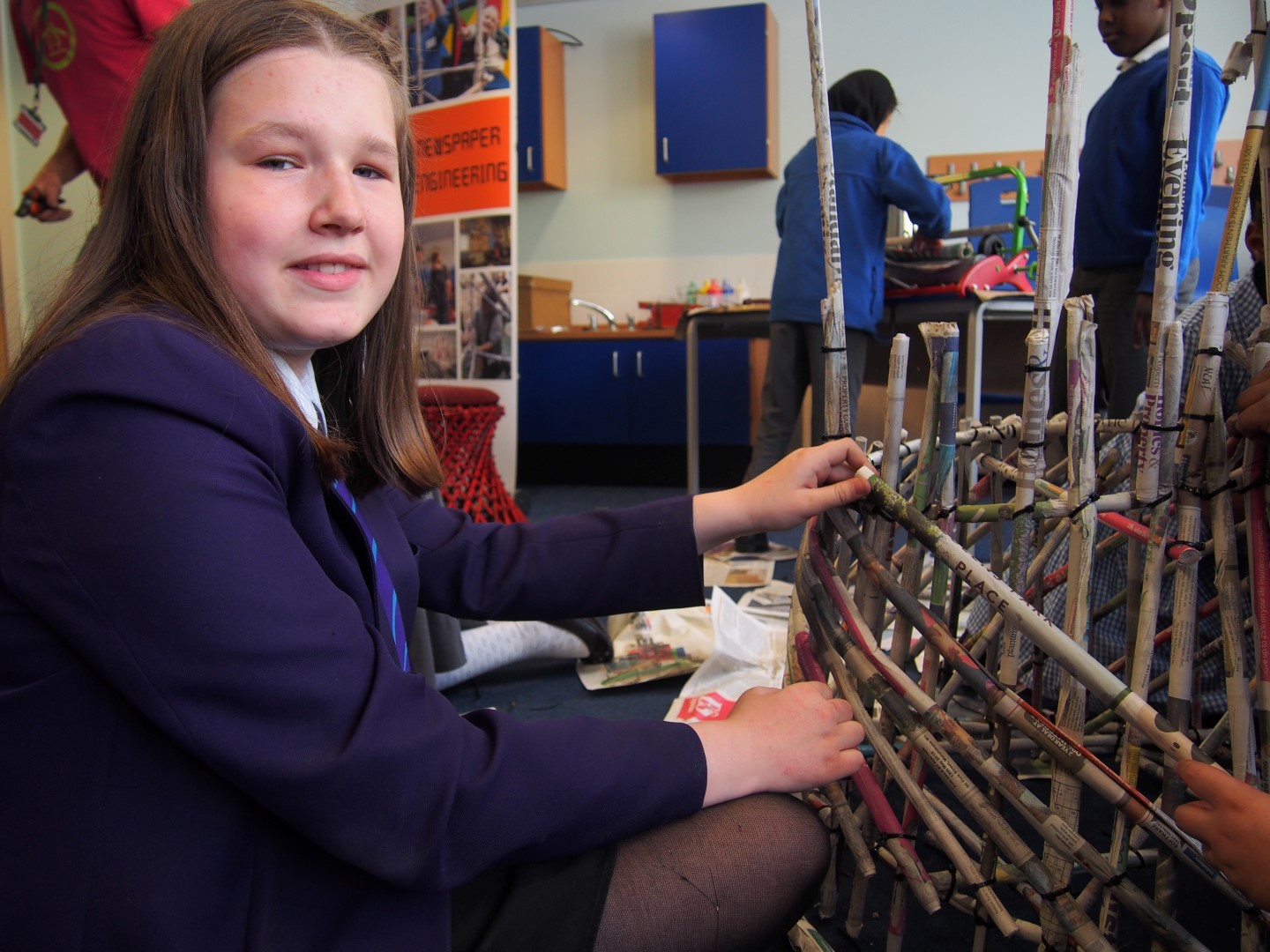 A pupil from a local secondary school helps out on the Newspaper Engineering activity at Willow Bank Primary Steam Co. Day