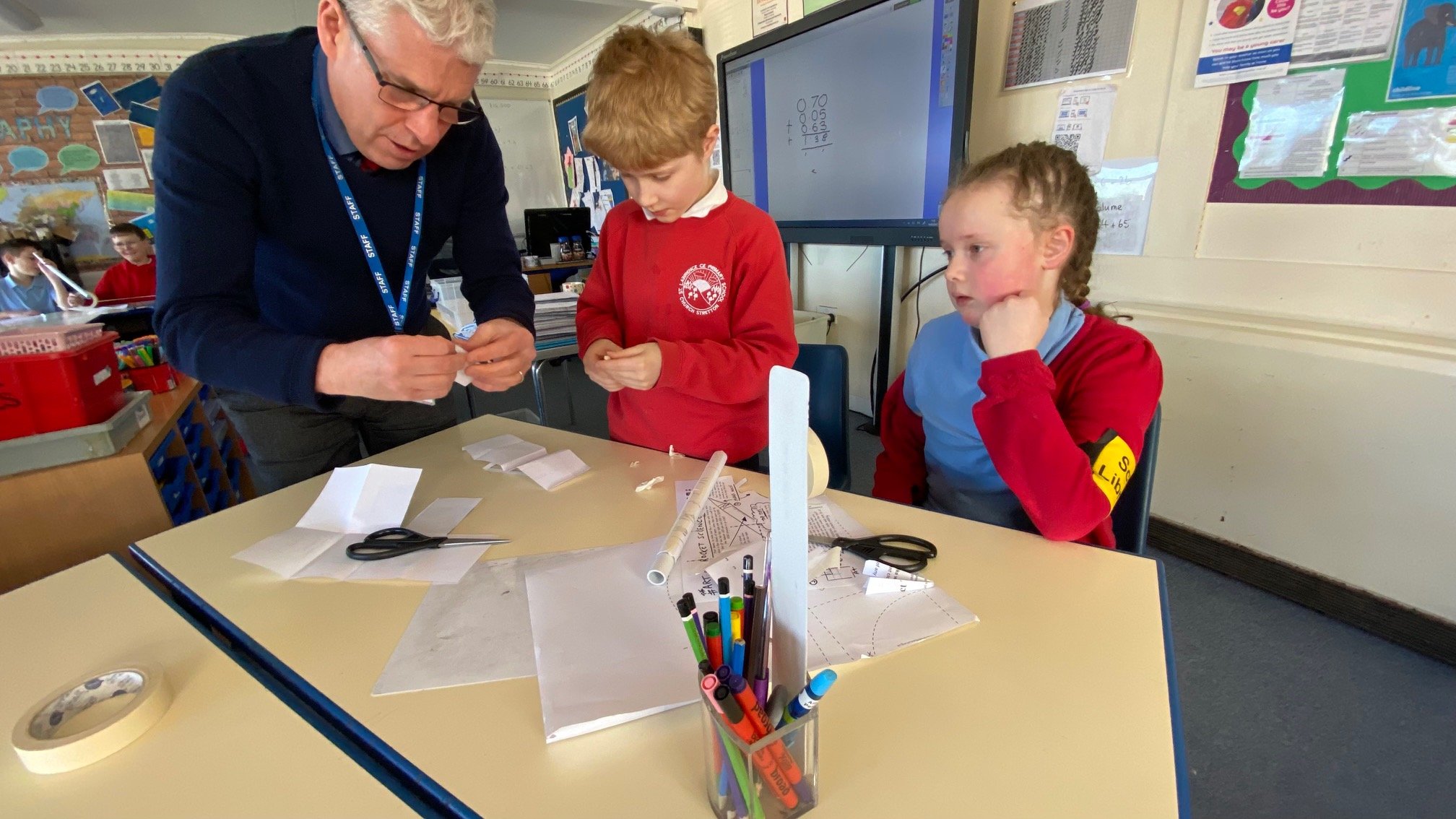STEAM Co OurMillion22 launch day at St Lawrence Primary Mr Alan Brannen - Headteacher shows TBC and TBC how to make paper rockets.jpg