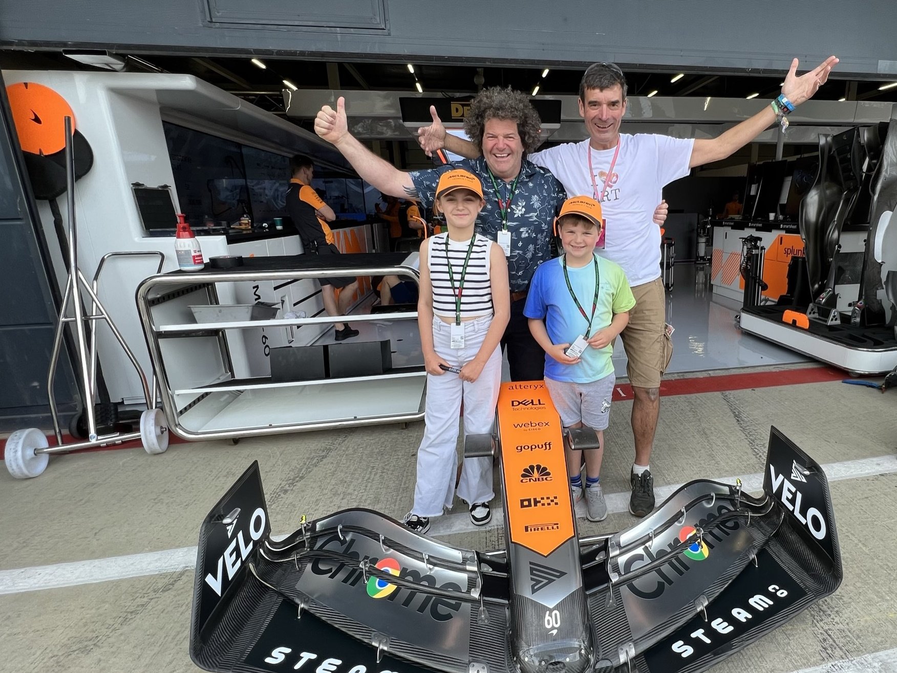 Yorkshire farmer Dad Richard Hampshire with kids and STEAM Co. branded McLaren F1 car nose cone and STEAM Co's Nick Corston in the McLaren pits at Silverstone.JPEG